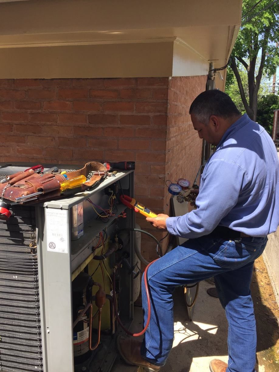 A man is working on an air conditioner outside of a building from AFA Service