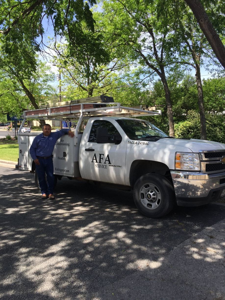 A man is standing next to a white truck from AFA Service
