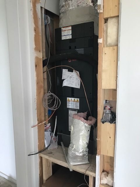 An air conditioner is sitting on top of a wooden shelf in a room from AFA Service