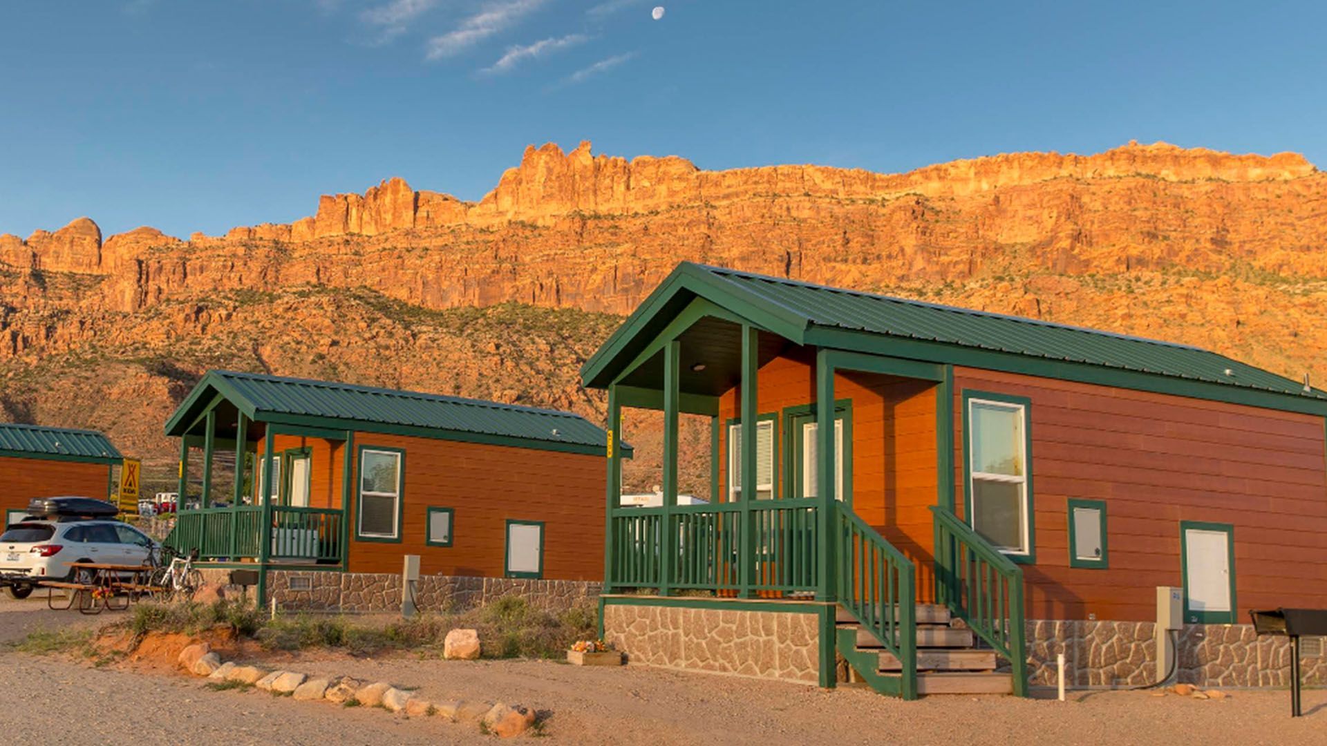 Cabin rentals at base of orange rocky cliffs.