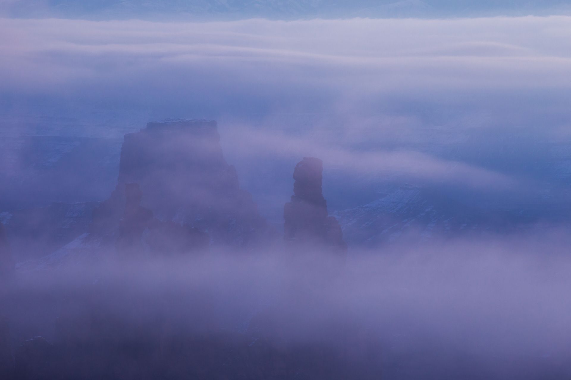 Fog over the spires of Canyonlands National Park.