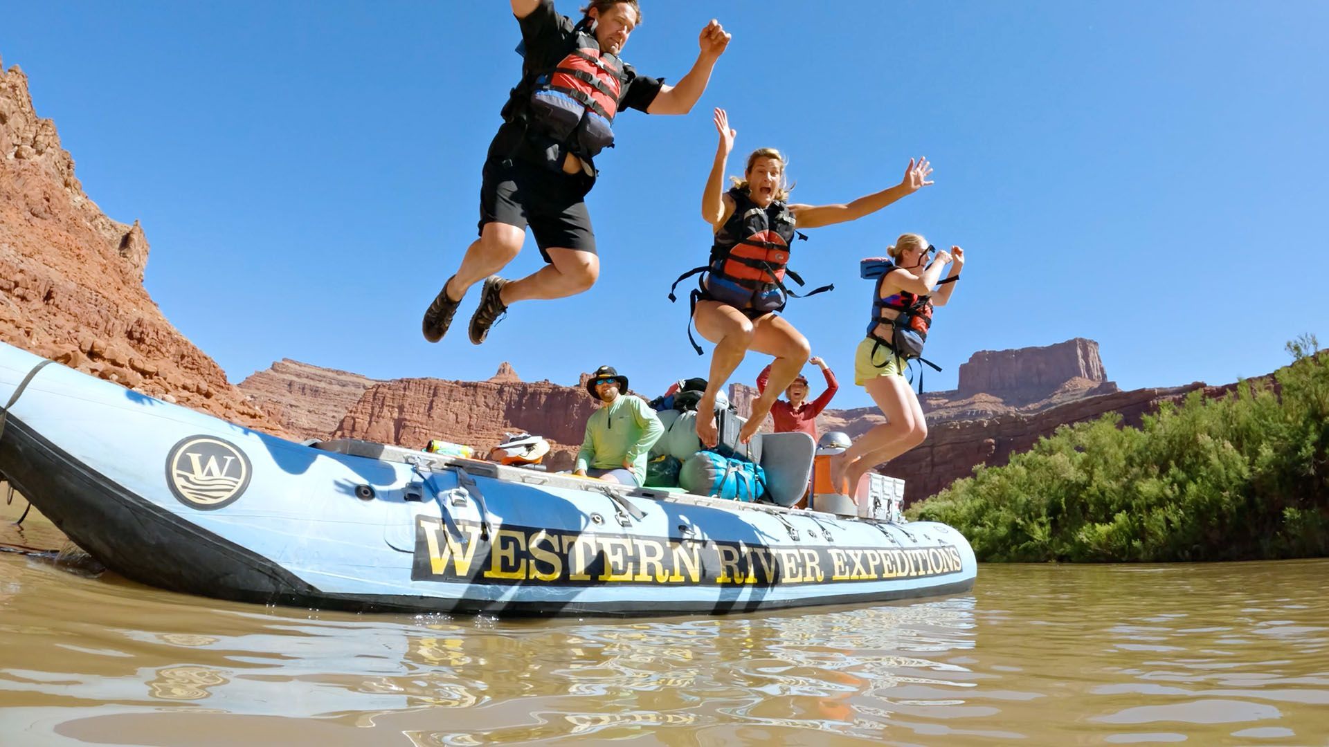 A family jumps off a raft in Desolation Canyon