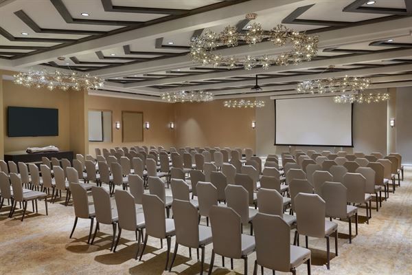 Indoor conference space at the Hoodoo Hotel showing rows of chairs with a large screen at the front of the room.