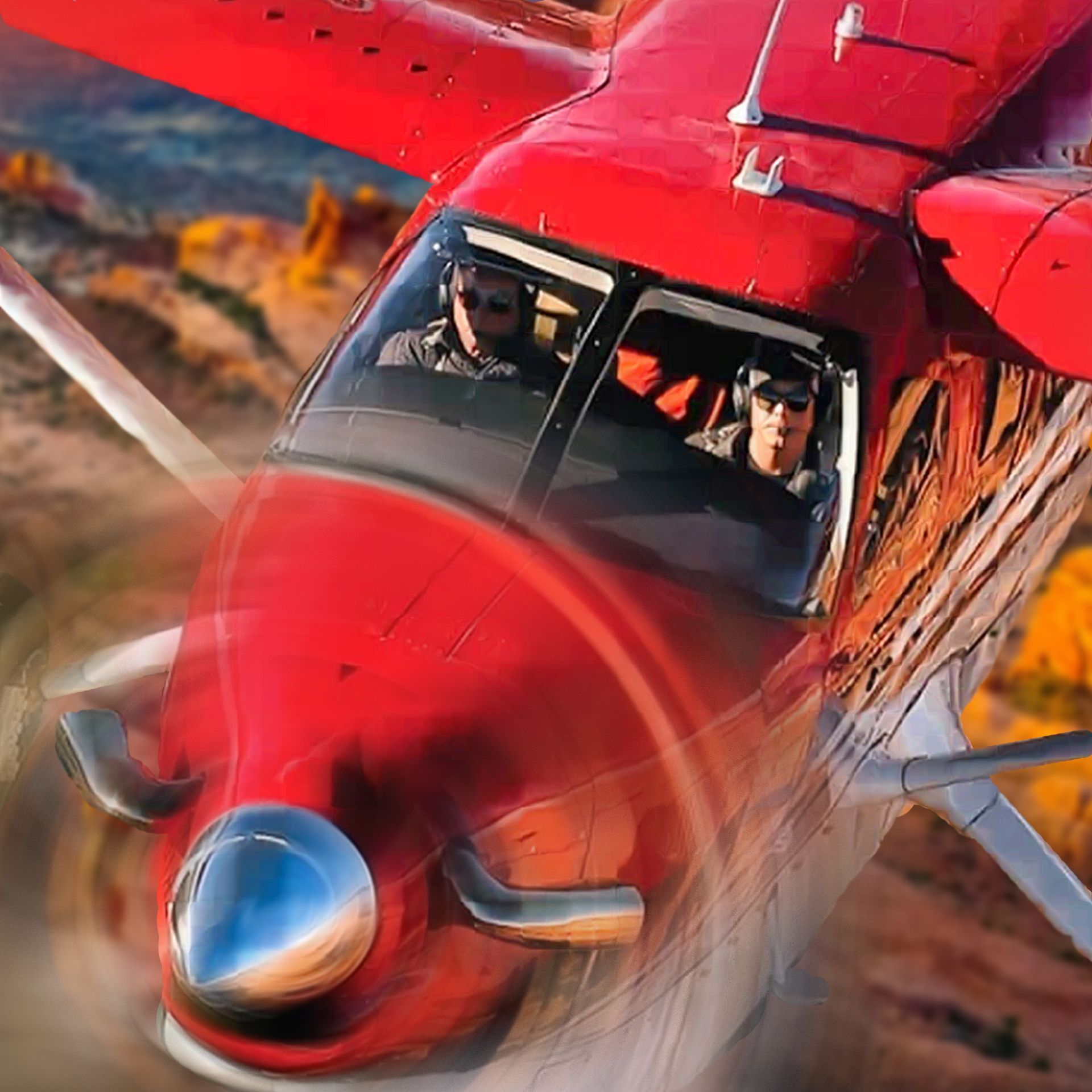 Red airplane in flight with pilot and passenger looking through the window, desert landscape in the background.