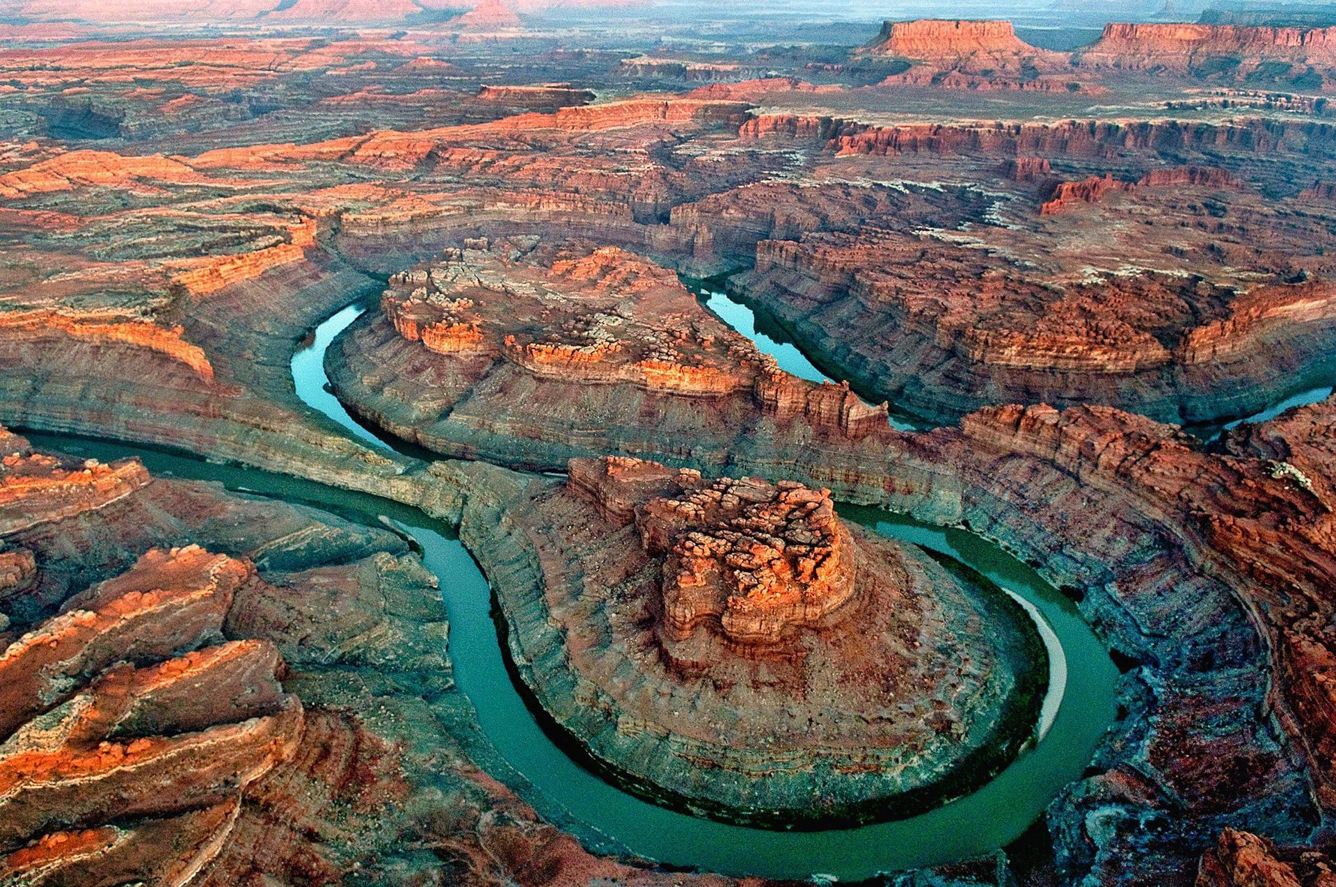 Canyonlands National Park in Utah. Red rock canyons and mesas with a river winding through.