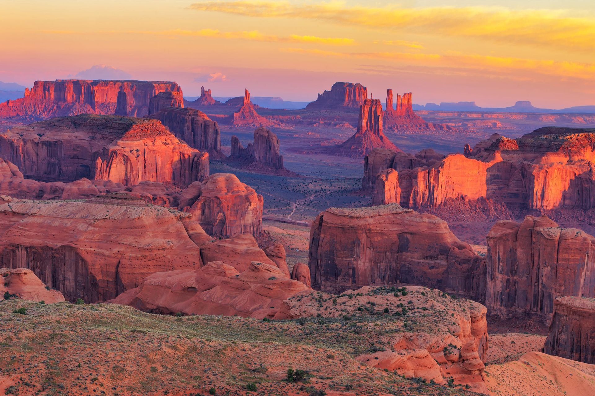 Monuments, buttes and red rock spires in the sunset glow near Moab - as seen from a sunset Canyonlands Air Tour.