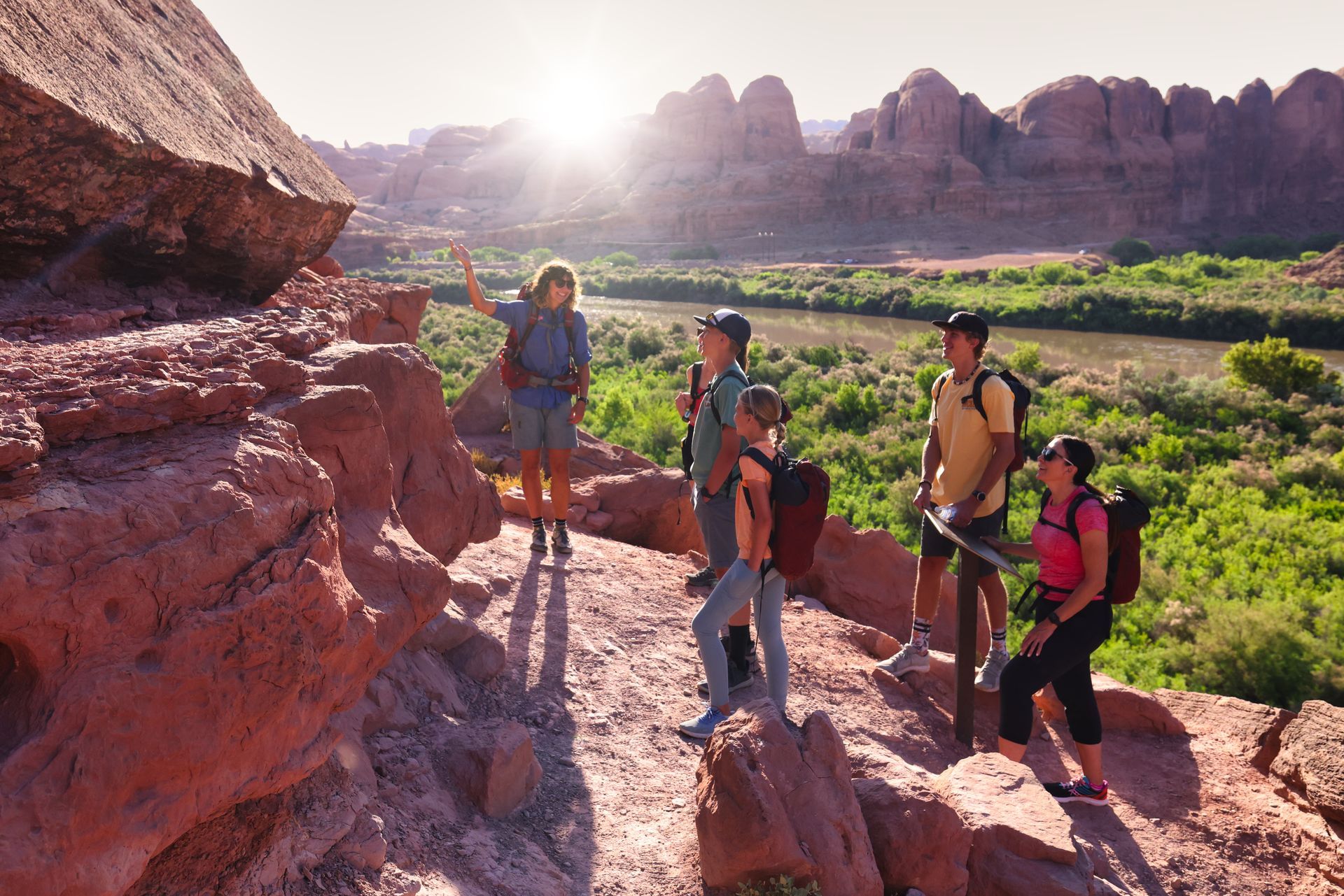 Group of people look at petroglyphs and dinosaur tracks near the side of Potash Road.