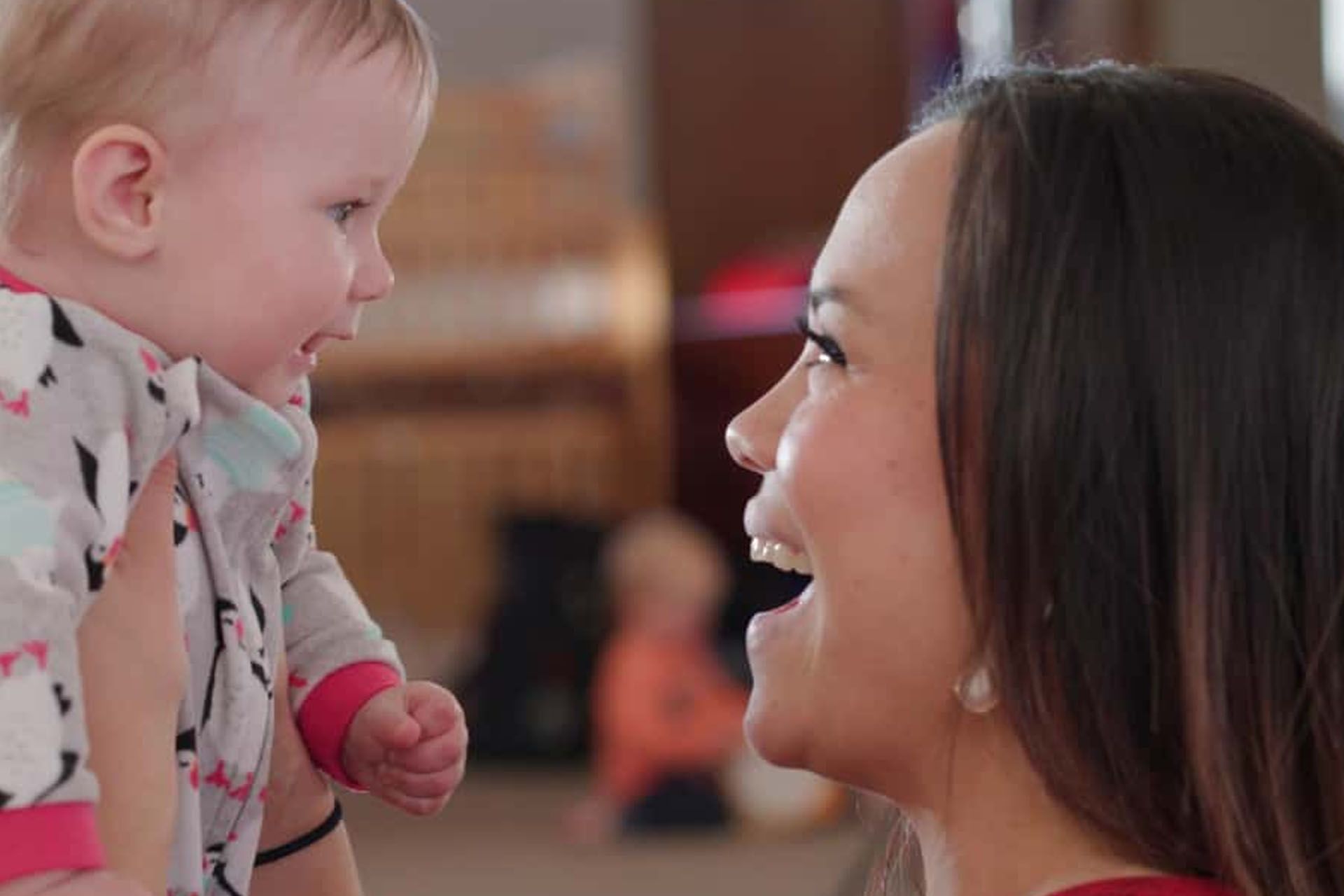 Young child smiles at caregiver.