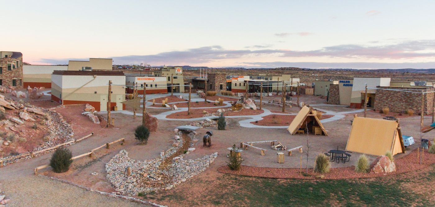 An aerial view of a desert village with tan buildings and tents.