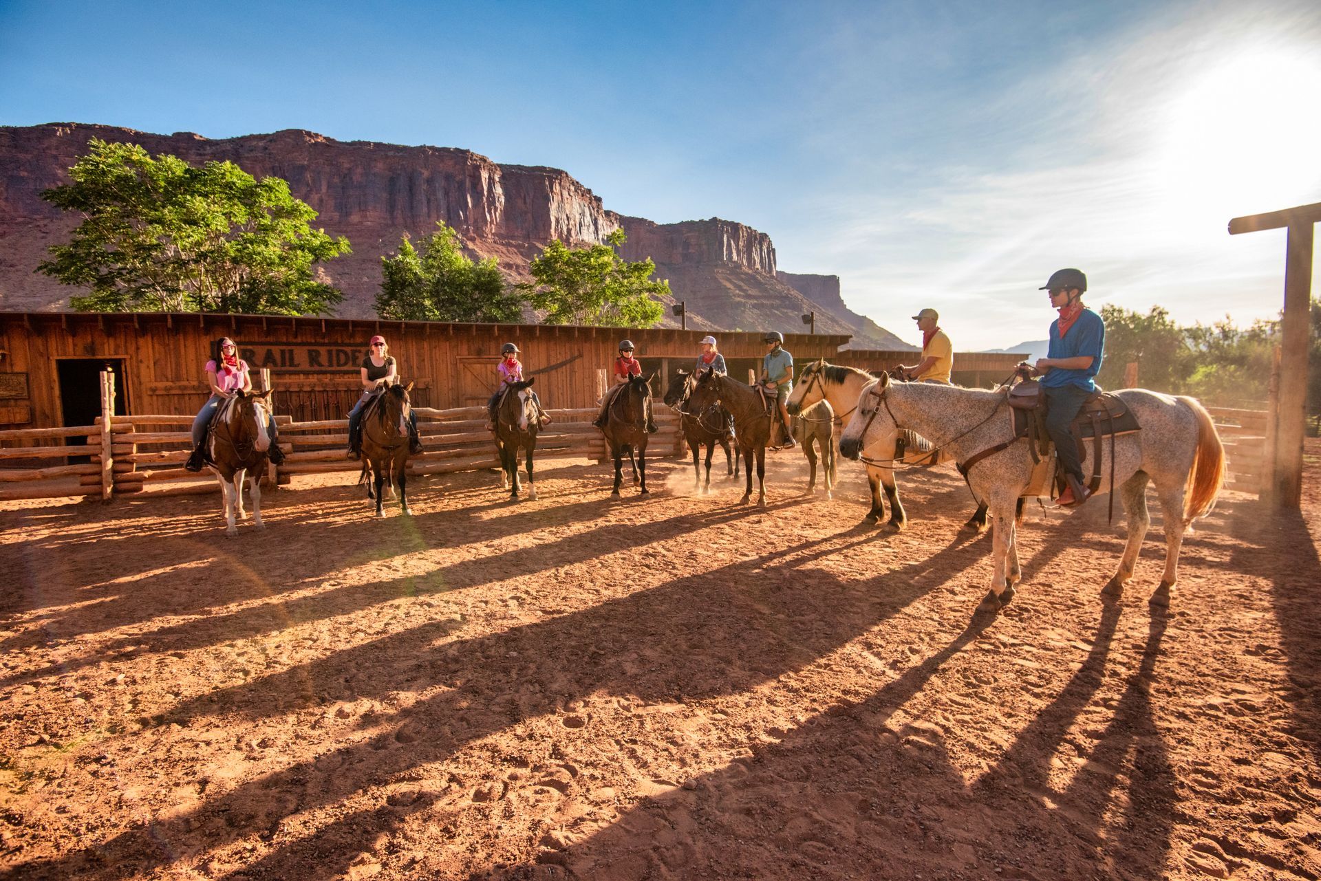 A group of people are riding horses in the desert