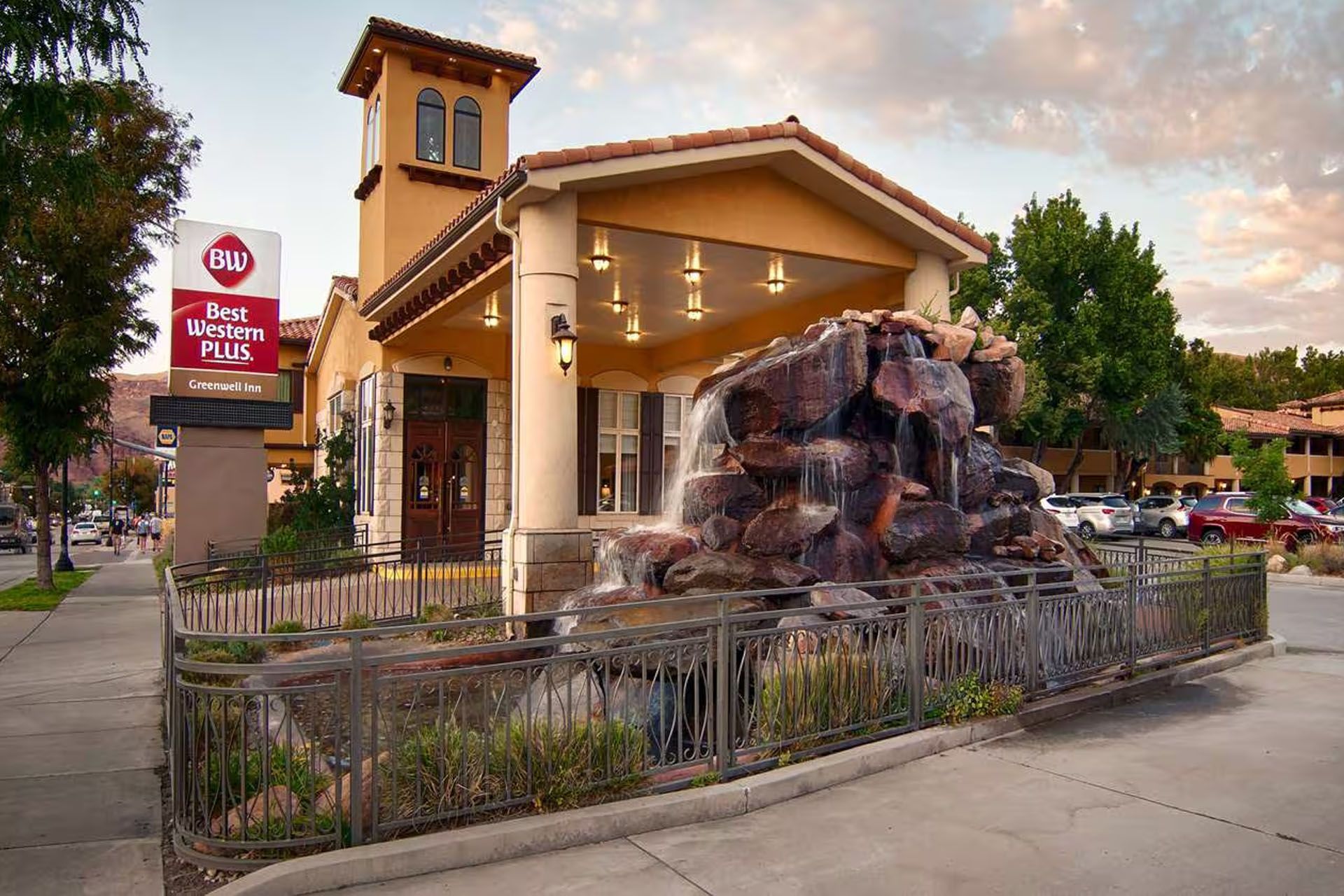 Dairy Queen with waterfall feature; tan building, red sign, fountain, sidewalk.