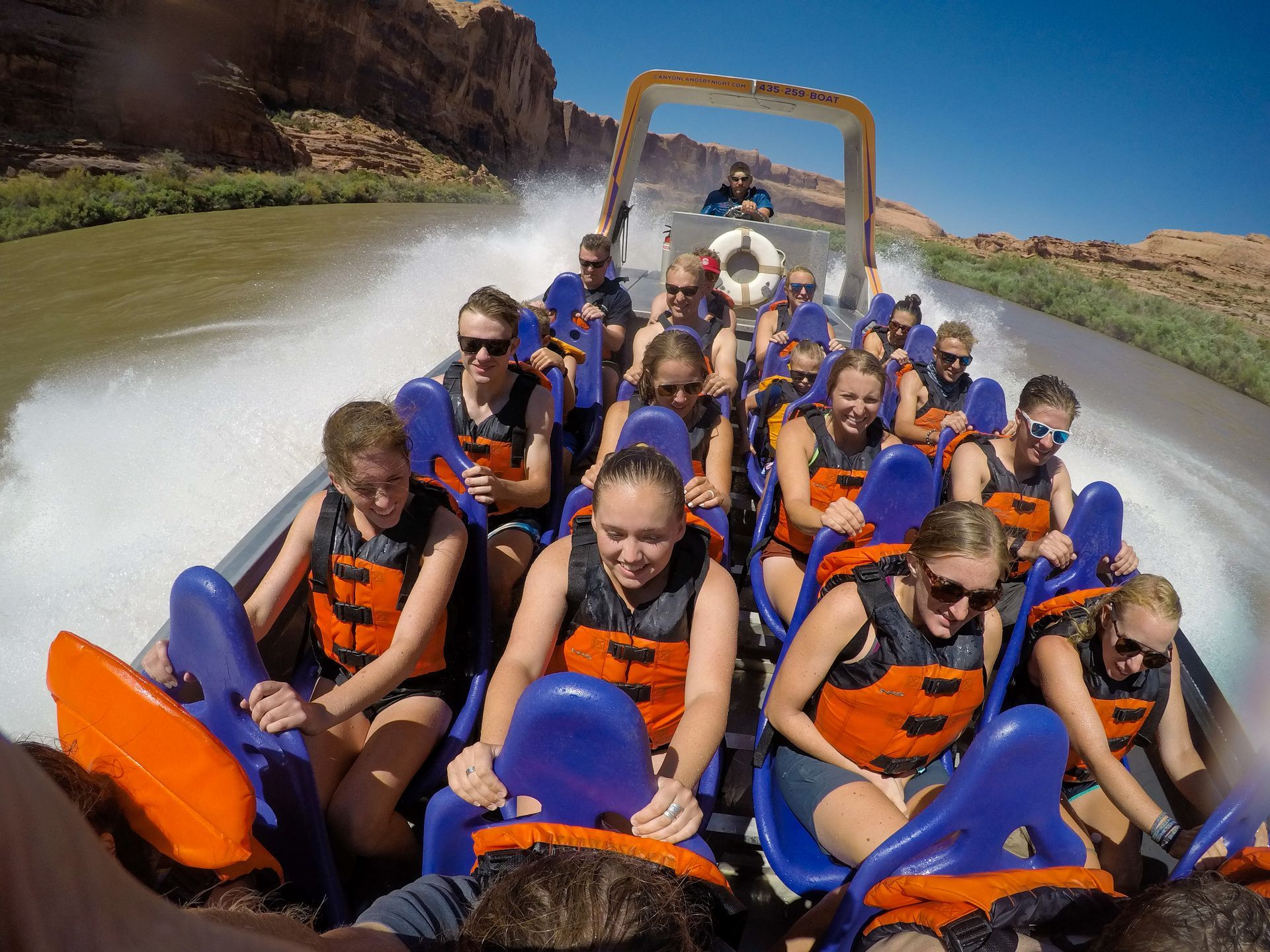 A group of people are riding a boat down a river.