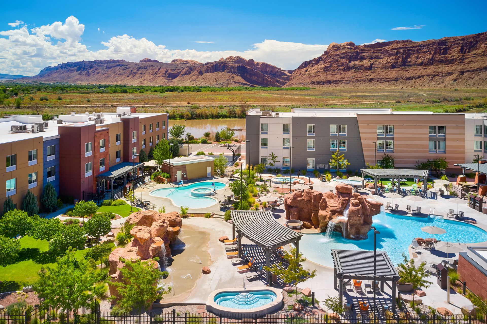 Aerial view of pool area shows two pools, lounge chairs, and hot tubs.