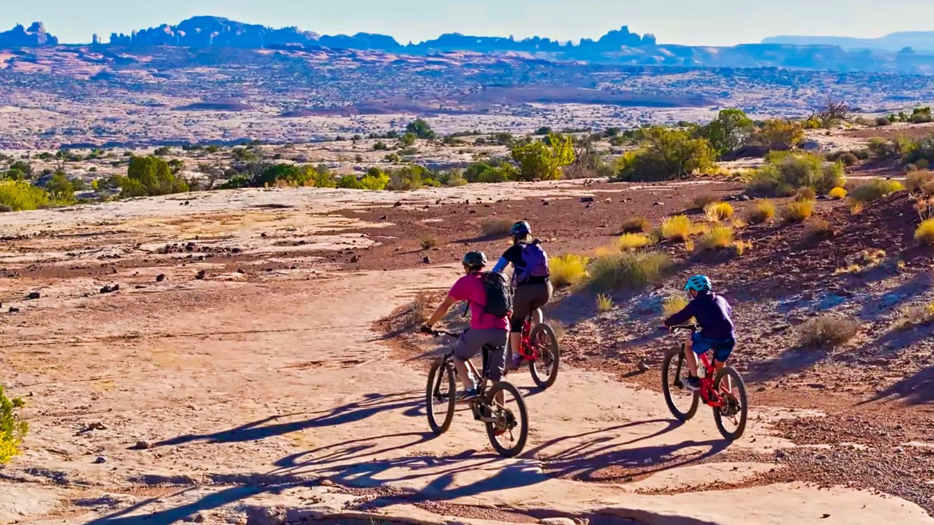 A group of people are riding bikes down a dirt road