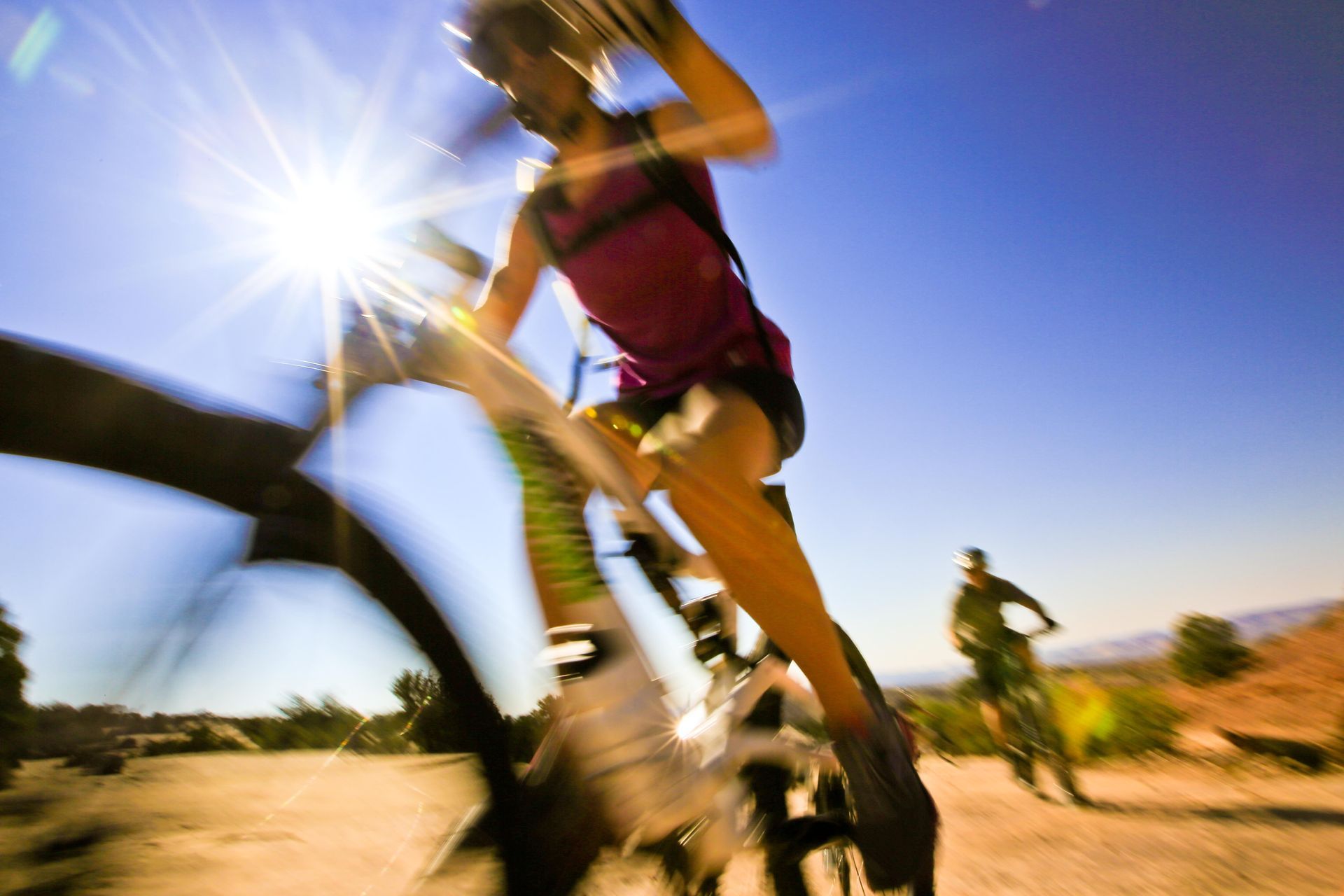 Mountain biker in motion with an up close of the bike and sunburst.
