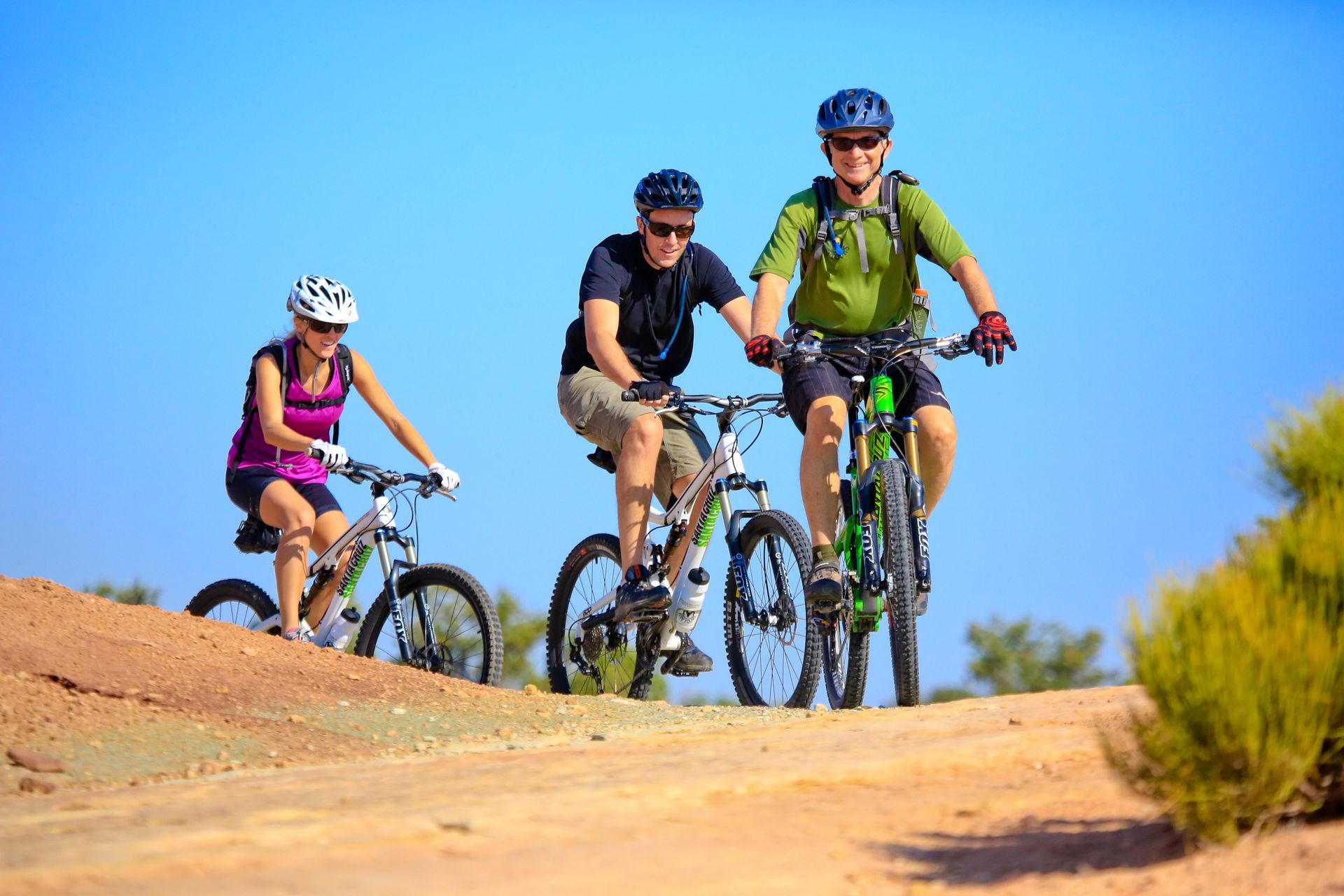 A group of people are riding bikes on a dirt road.