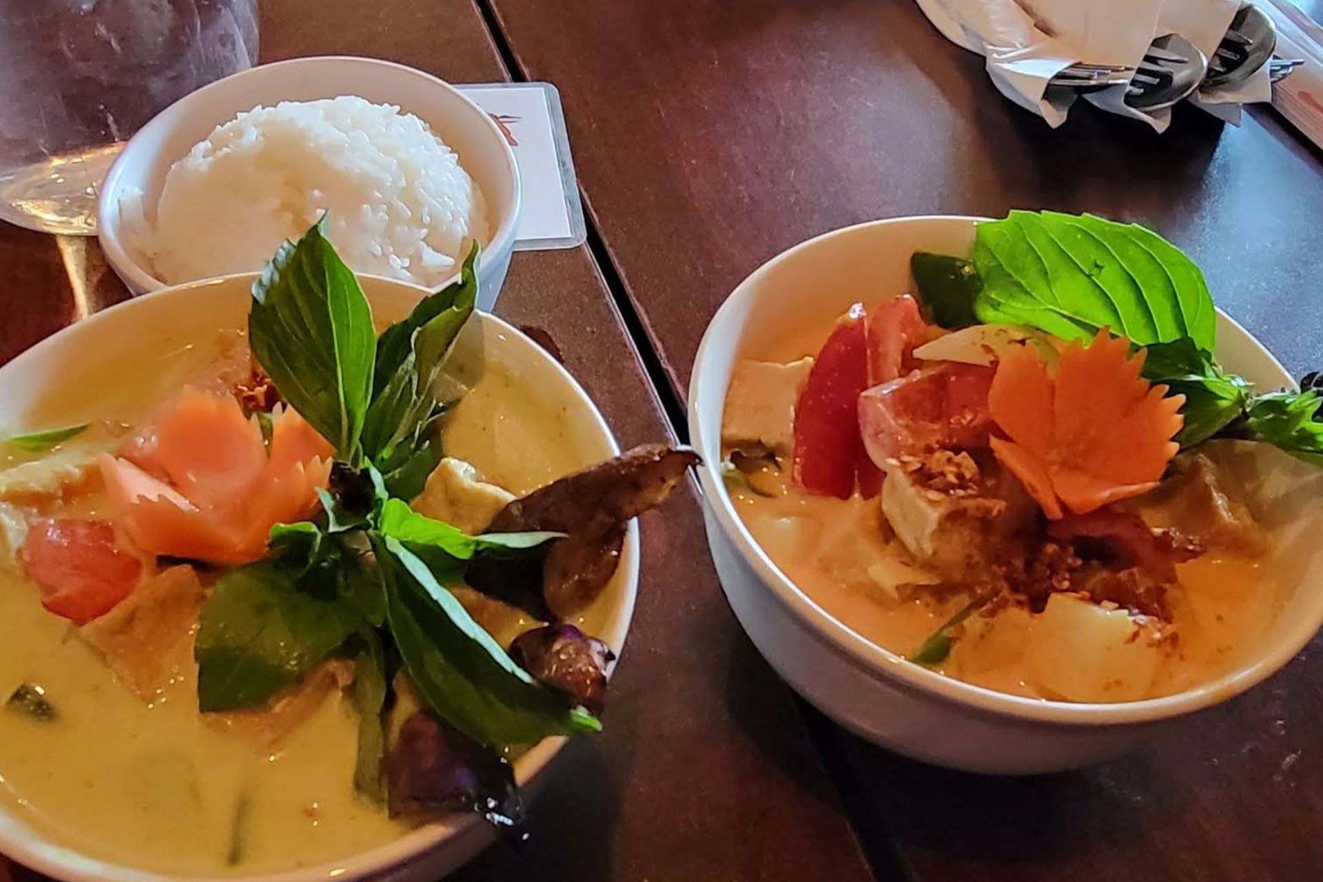 Restaurant with red exterior, wooden accents, clear plastic coverings, and sign.