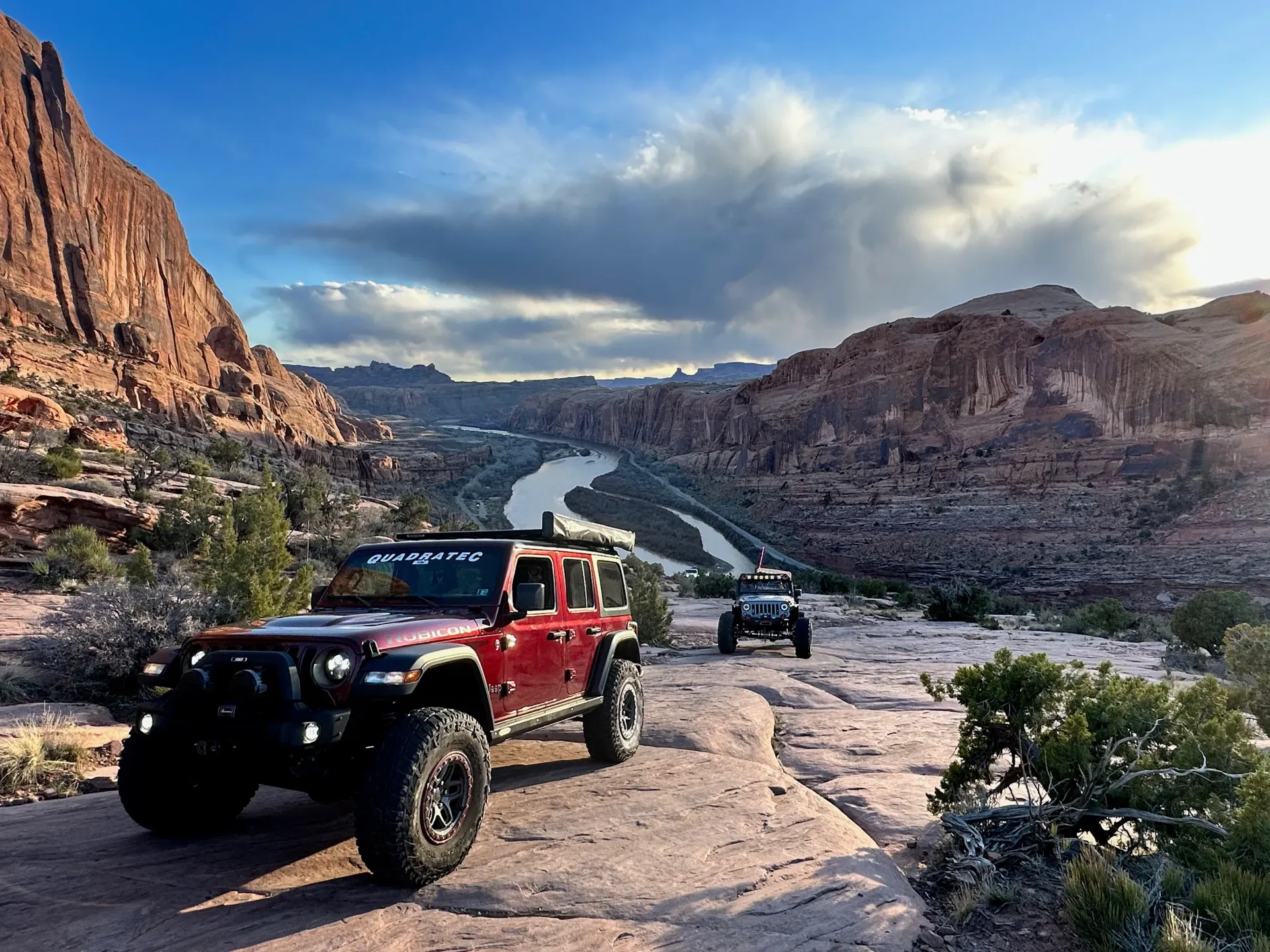 Two jeeps climb up the slickrock trail on the Moab Rim.