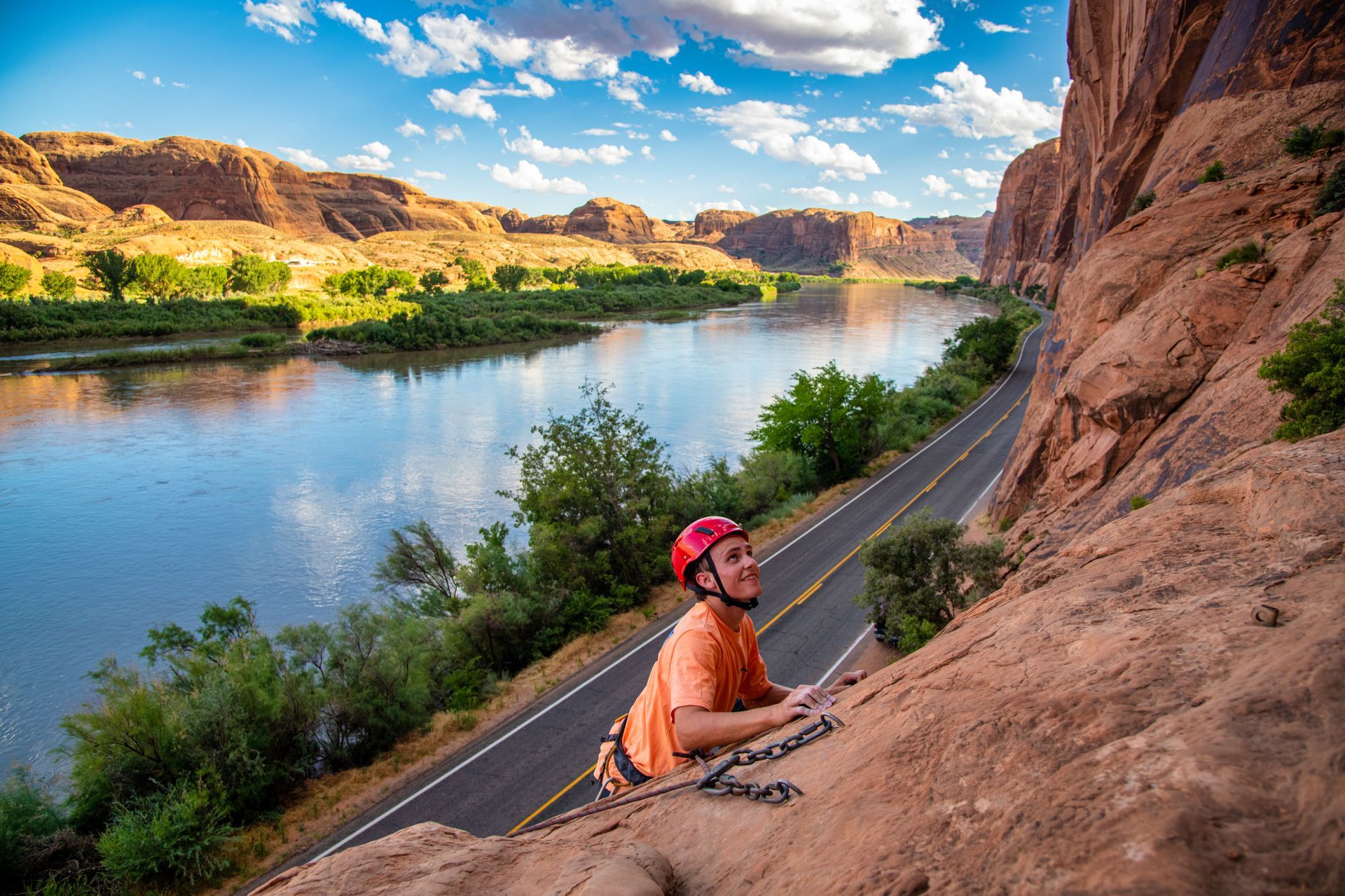 A man is climbing a rock wall with a rope.