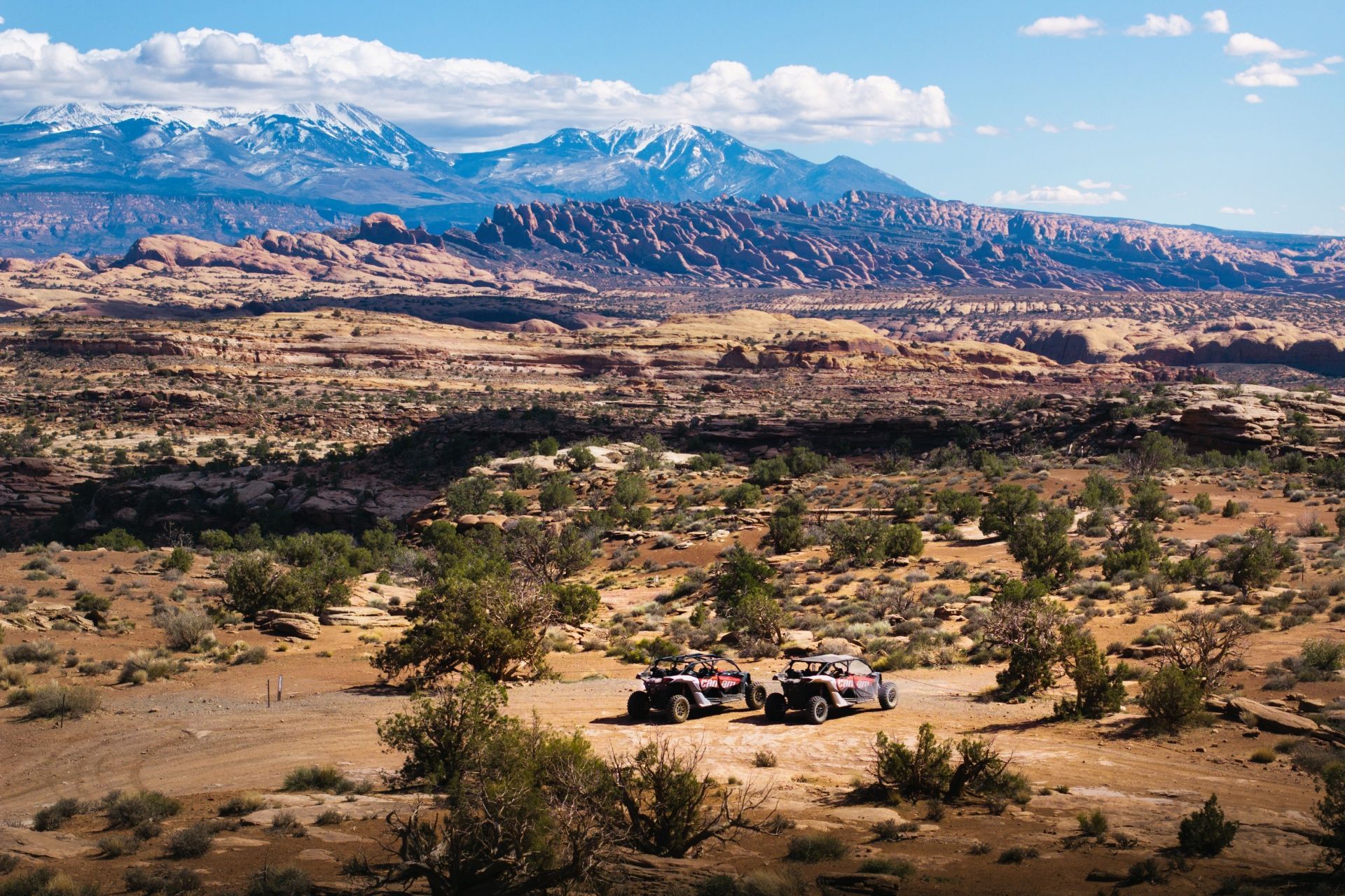 Off-road vehicles parked near the rope swing location with the La Sal Mountains in the background