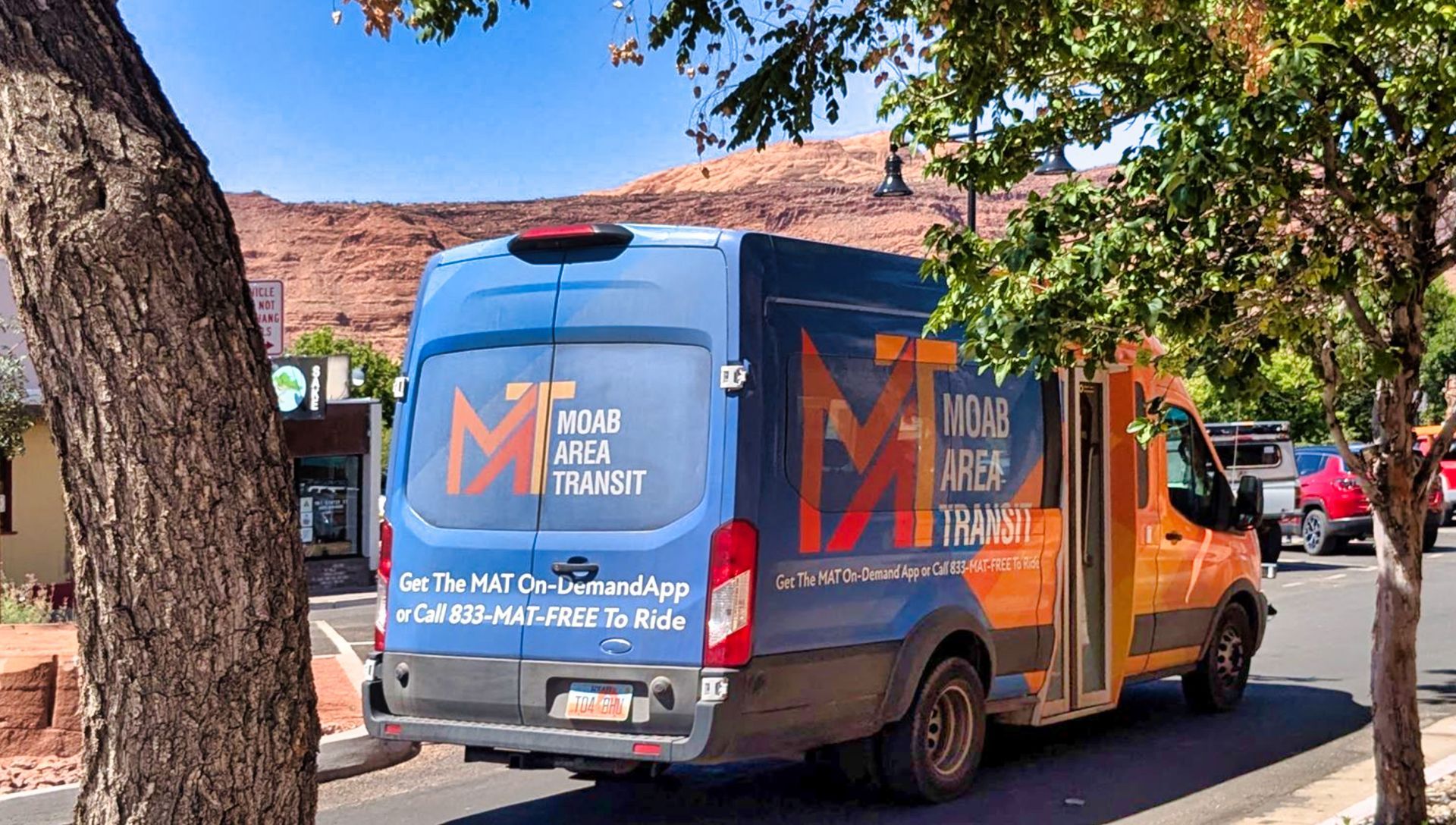 A local Moab Area Transit shuttle is shown at a pickup location along Moab Main Street.