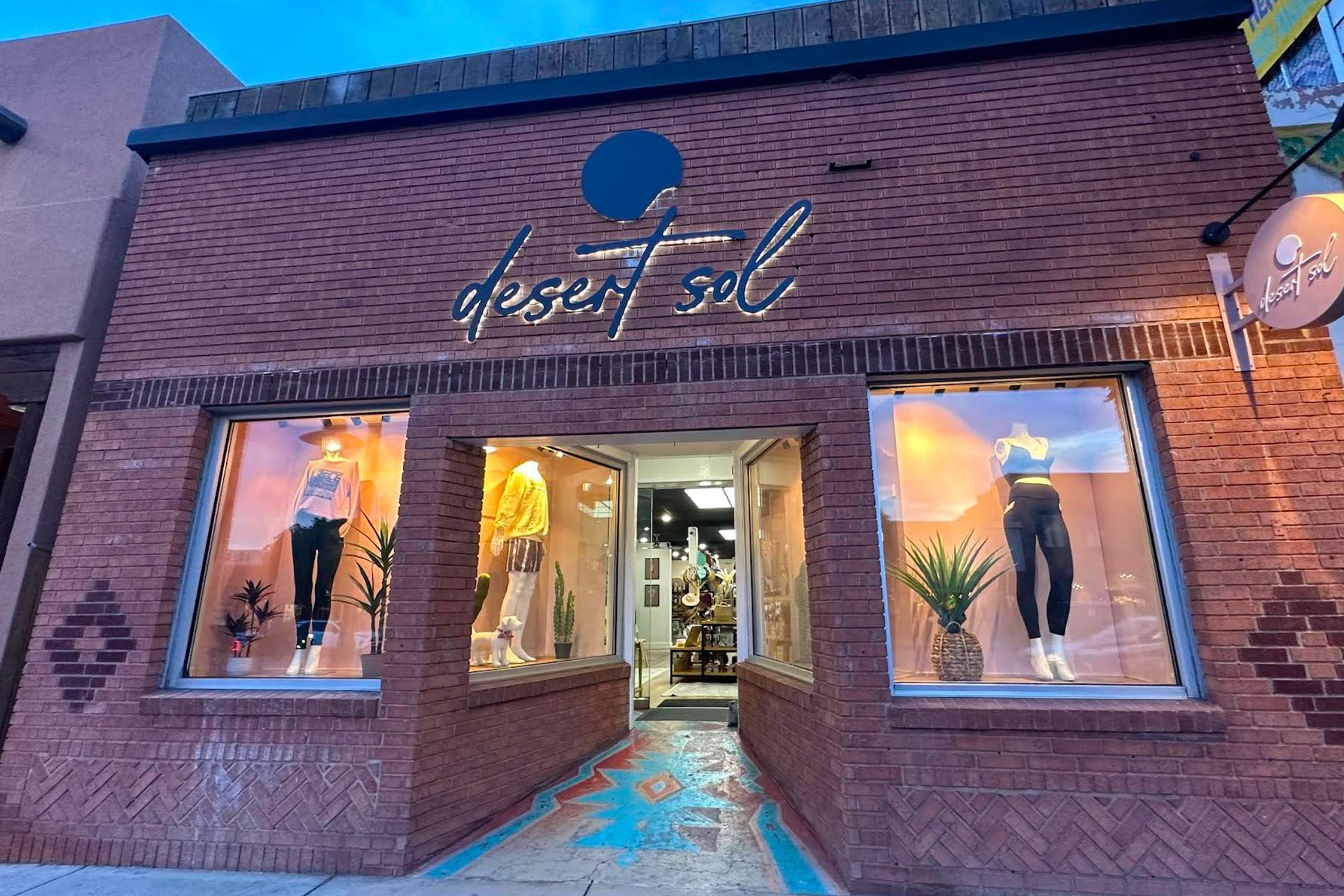 Desert Sol boutique with mannequins in windows; brick building with turquoise accents.