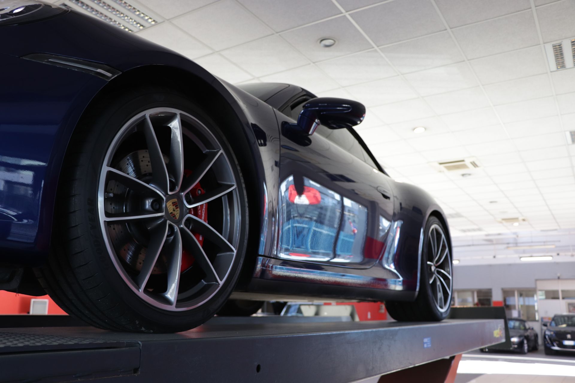 inquadratura dal basso di vettura rialzata in officina