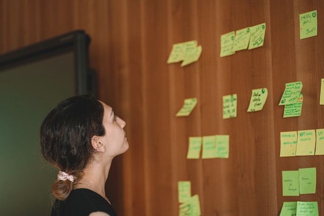 Girl looking at post its at facilitated workshop