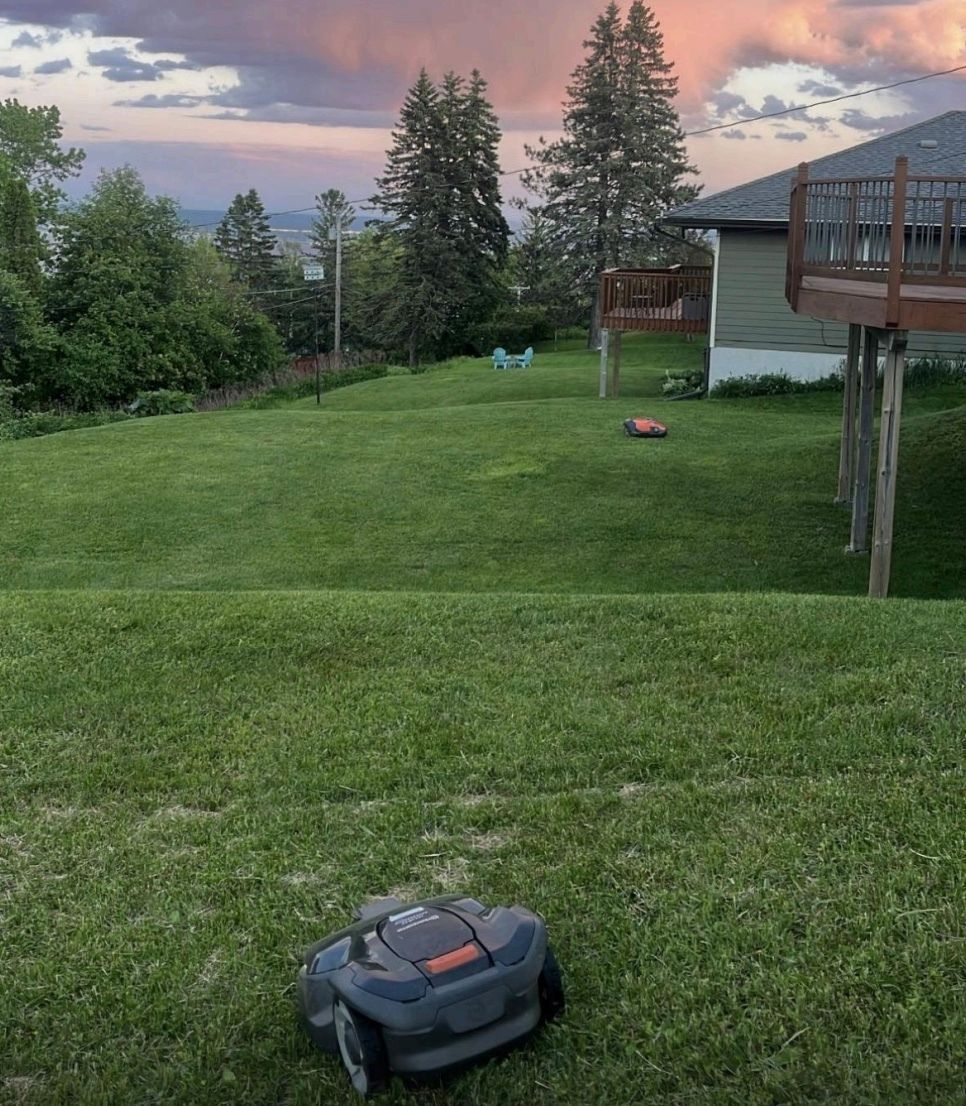 A large house is sitting on top of a lush green field.