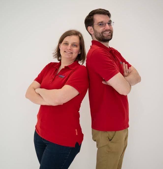 Ein Mann und eine Frau stehen Rücken an Rücken mit verschränkten Armen