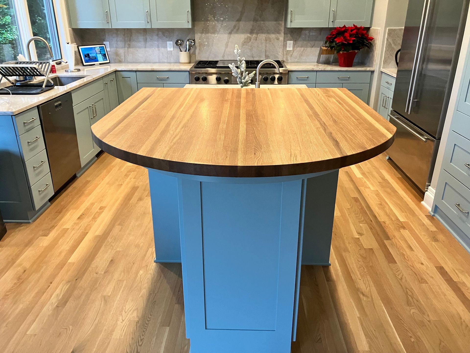 Kitchen with blue cabinets, wood countertops, and a central island.