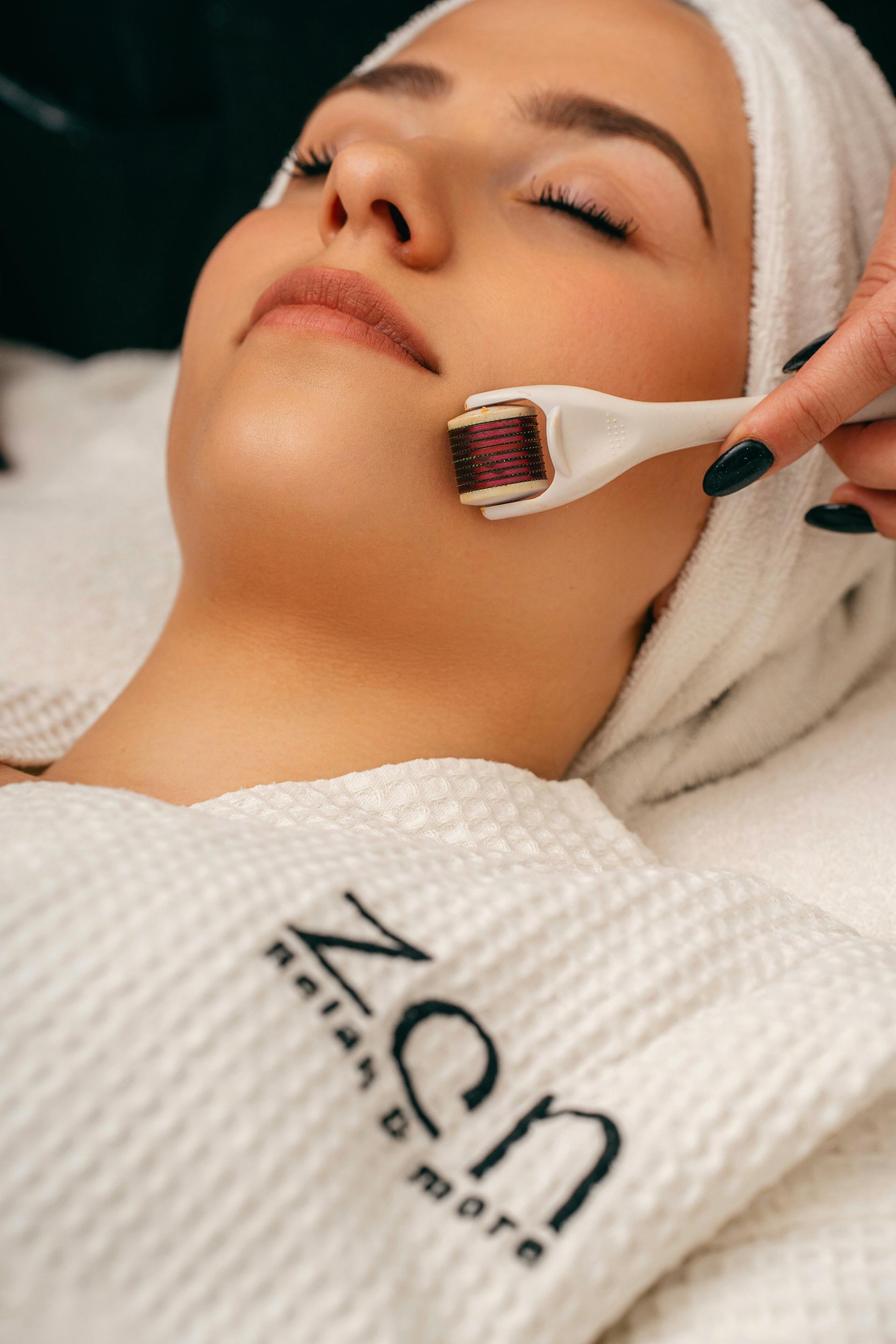 Une femme reçoit un soin du visage avec un rouleau sur son visage.