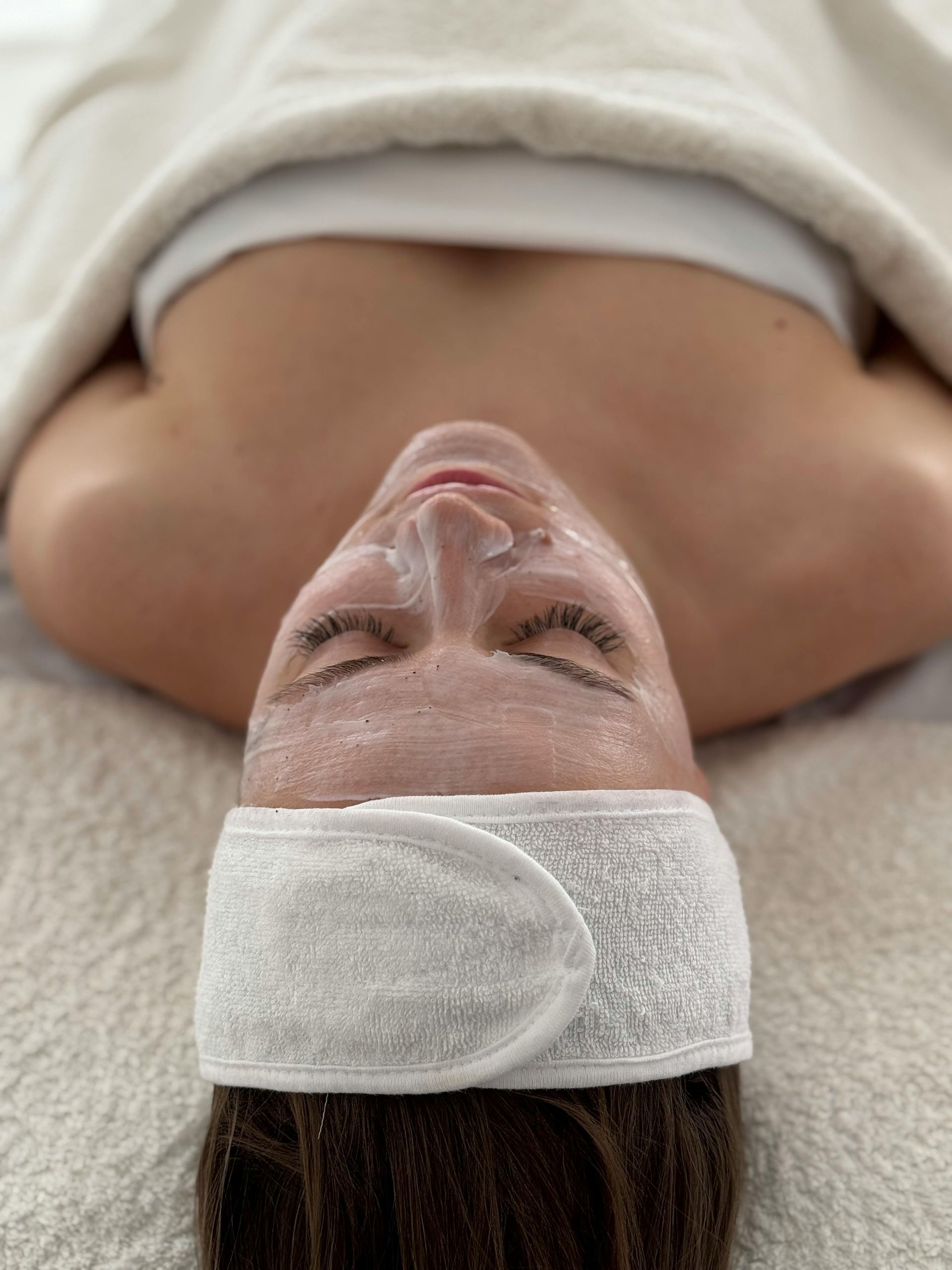 Une femme est allongée sur le dos avec un masque sur le visage.