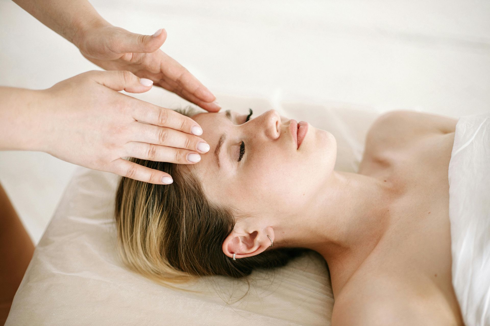 Une femme reçoit un massage de la tête dans un spa.