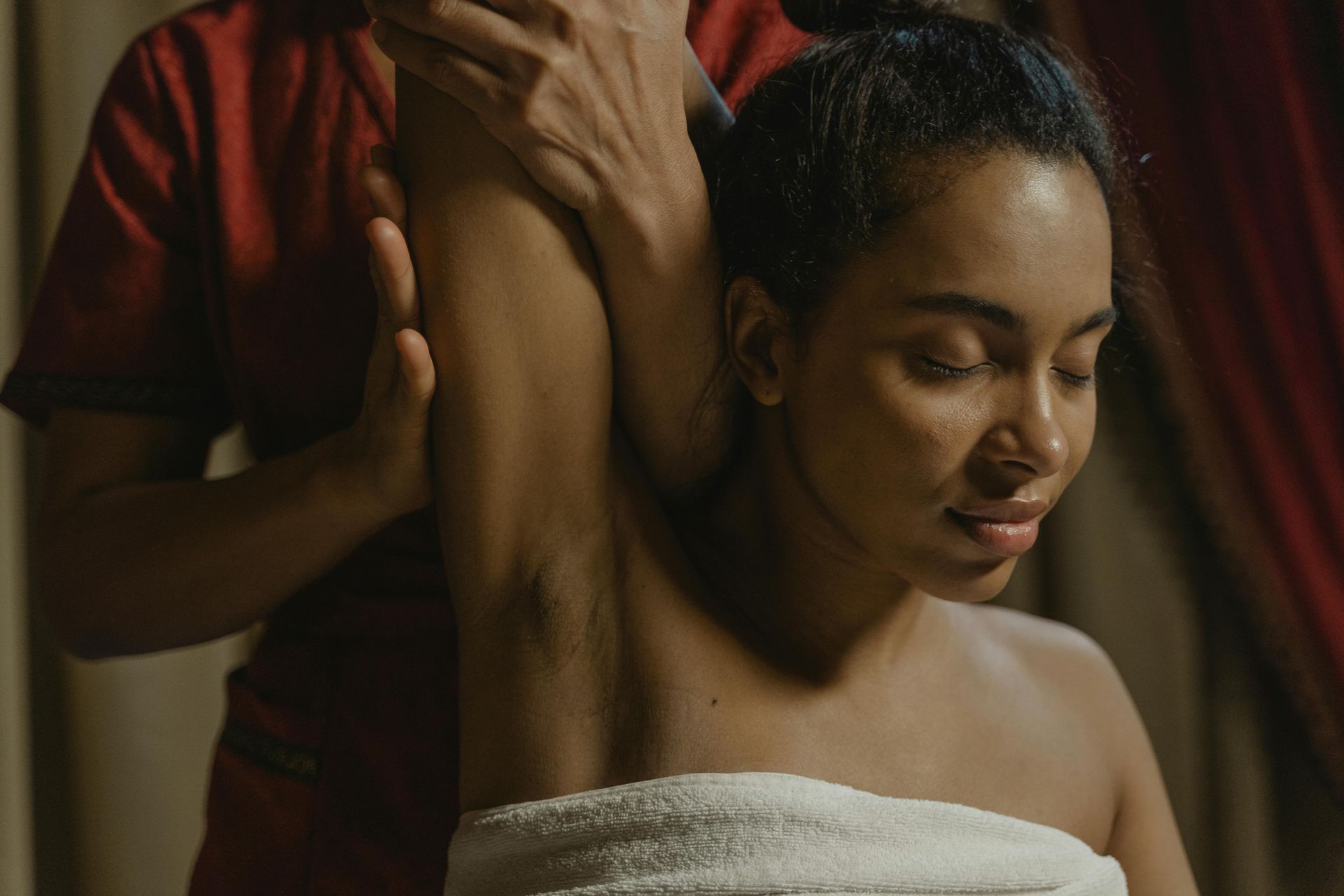 Une femme enveloppée dans une serviette reçoit un massage d'un homme.