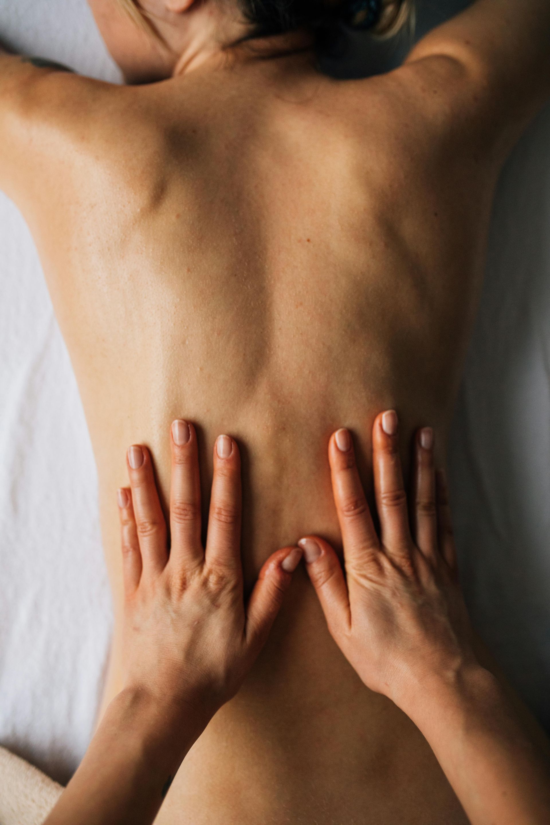 une masseuse pose ses mains sur le dos d'une massée 
massage bébé; Massage dos, massage détente, massage tonique, massage bien être, massage sur mesure, massage relaxant, massage visage colmar, ribeauvillé, horbourg wihr, wintzenheim 