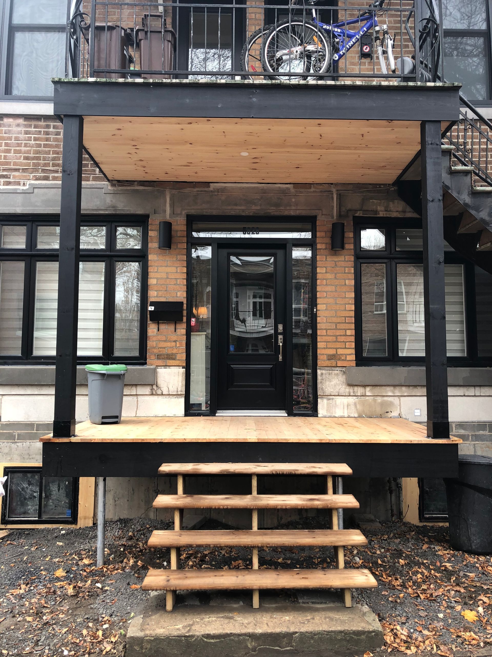 La façade d'une maison avec un porche et des escaliers en bois.