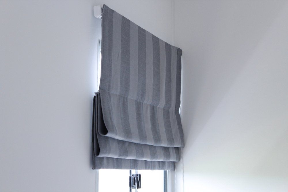 Grey Roman Blinds On The Window — Studio Curtains & Blinds in Mount Gravatt, QLD