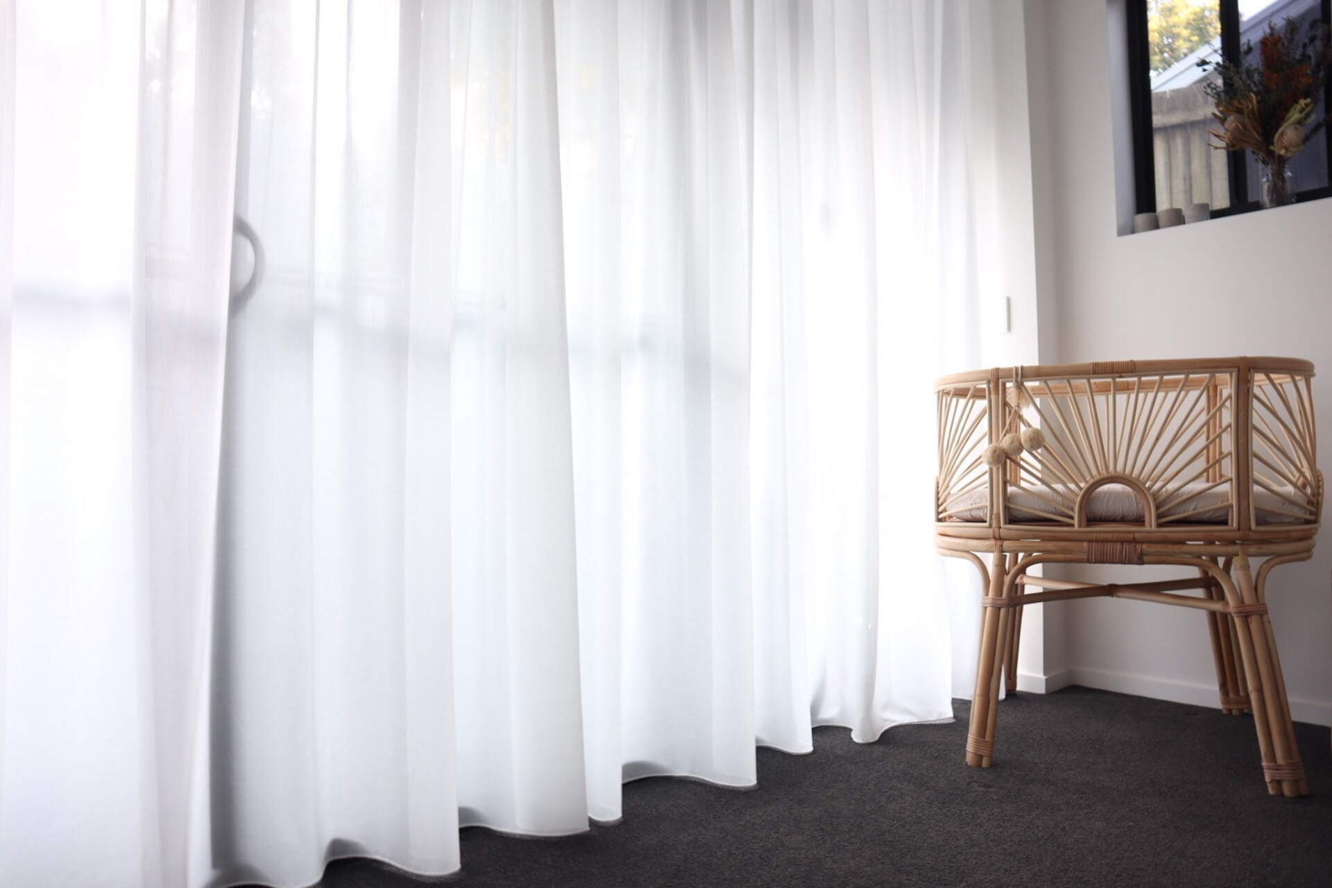 White Curtains & A Rattan Baby Crib — Studio Curtains & Blinds in Mount Gravatt, QLD