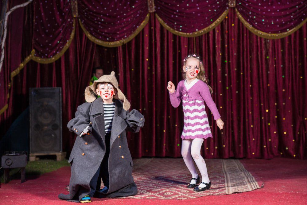 Two Children  Dancing On Stage With Red Velvet Curtains — Studio Curtains & Blinds in Mount Gravatt, QLD