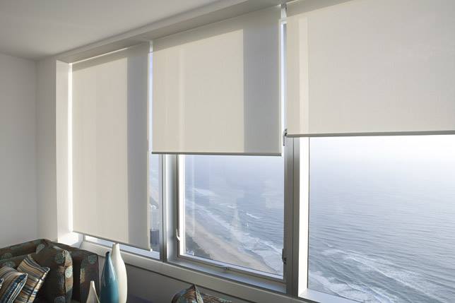 White Roller Blinds On A Glass Window — Studio Curtains & Blinds in Mount Gravatt, QLD