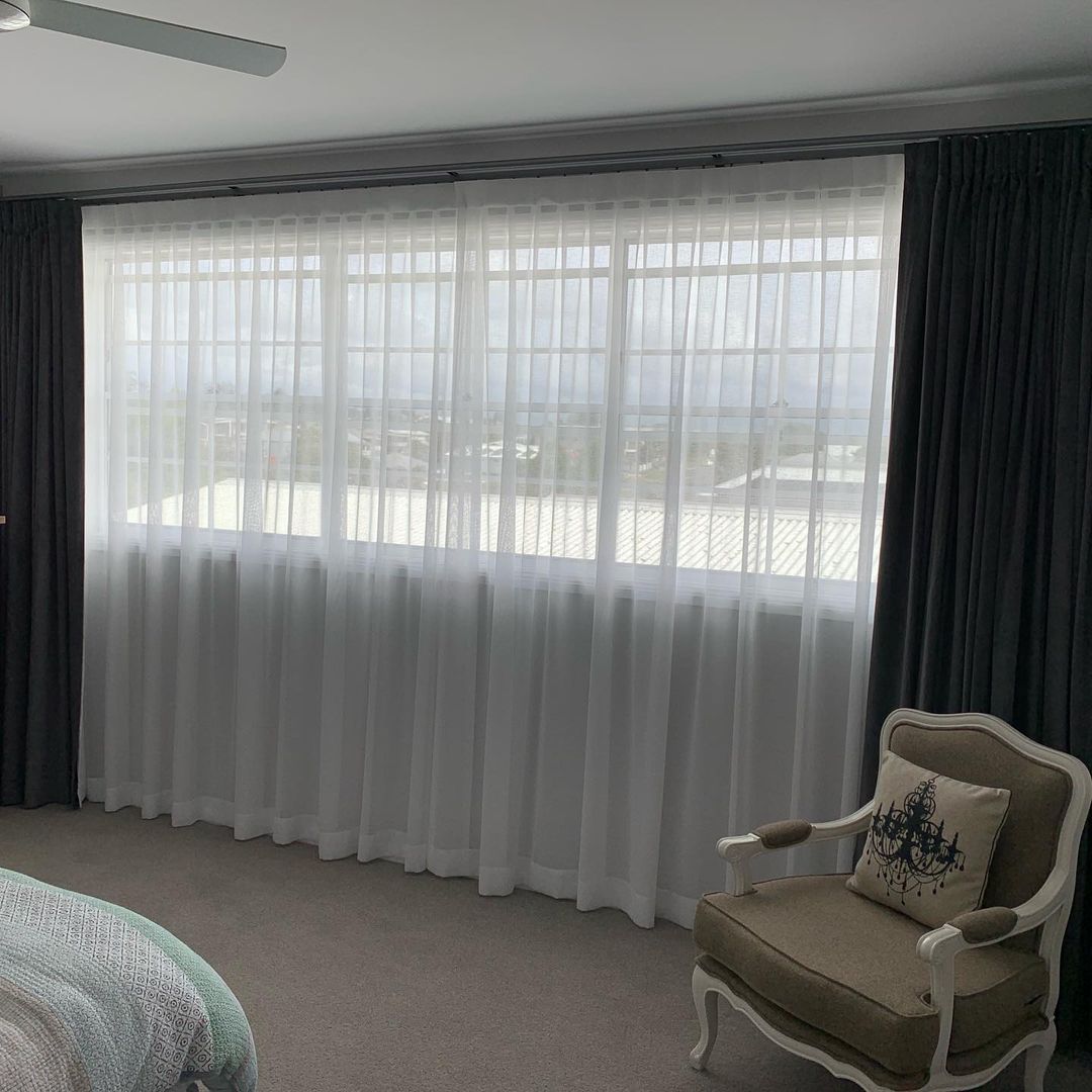 White Inverted Pleat Curtains & A Cozy Chair — Studio Curtains & Blinds in Mount Gravatt, QLD