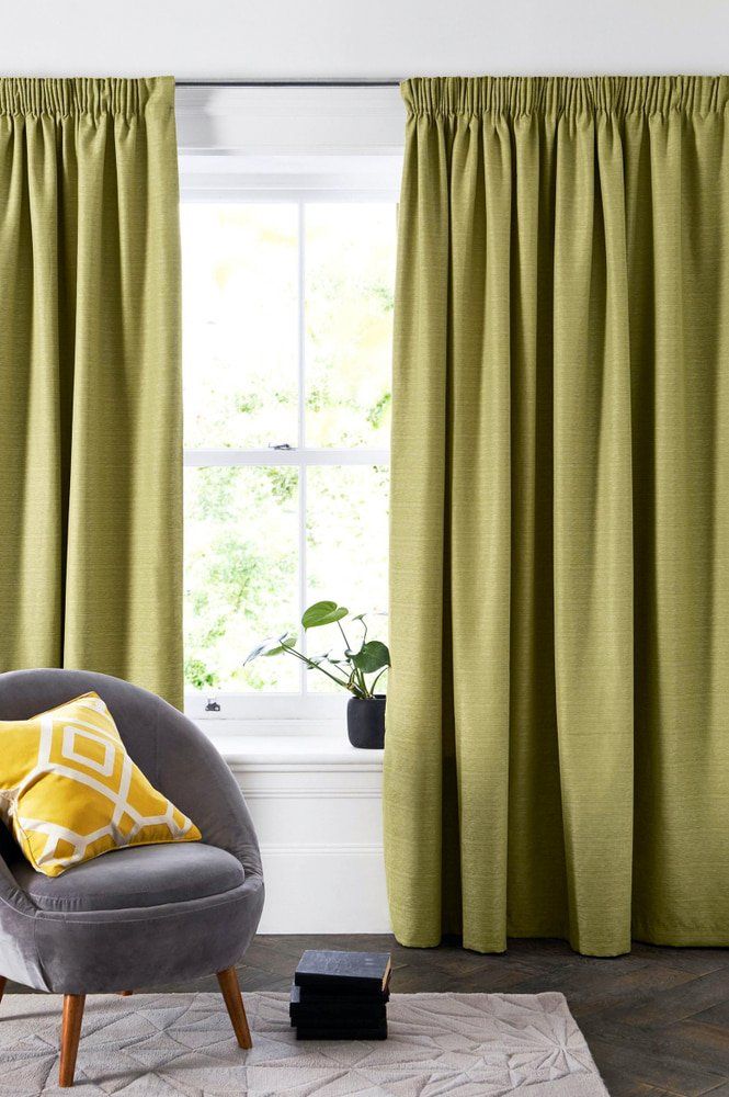 Green Pencil Pleated Curtains & A Cozy Chair — Studio Curtains & Blinds in Mount Gravatt, QLD