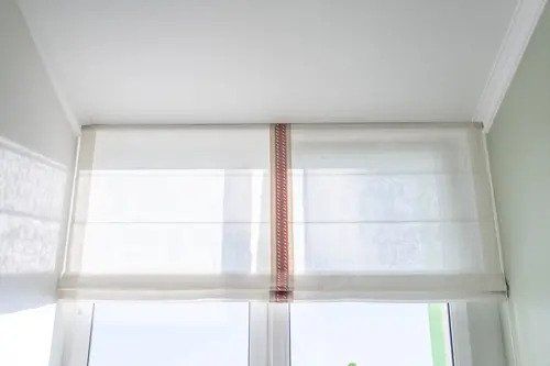 White Roman Blinds On A Glass Window — Studio Curtains & Blinds in Mount Gravatt, QLD