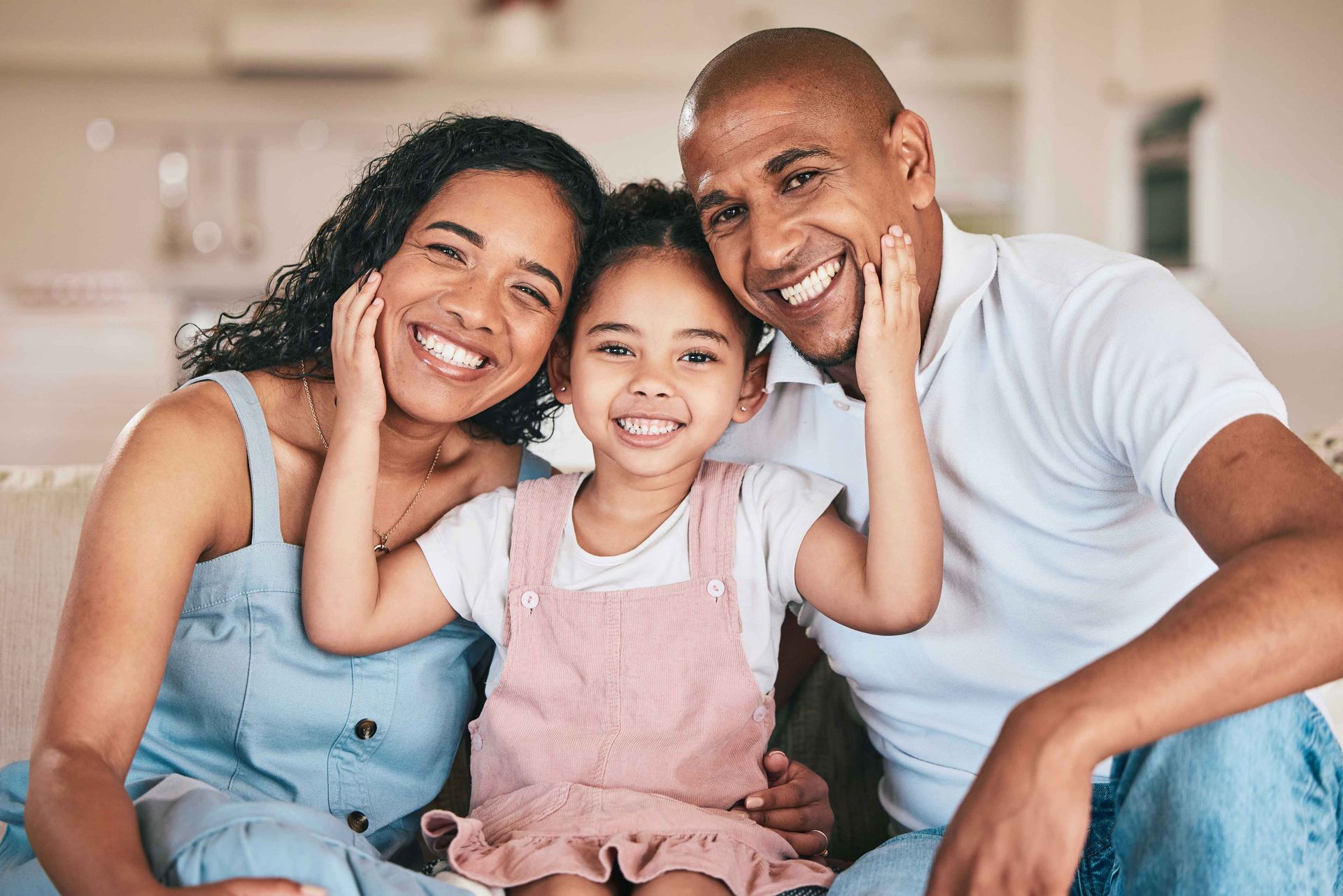 Family of three smiles for the camera, touching their faces. Family of three smiles for the camera, touching their faces.