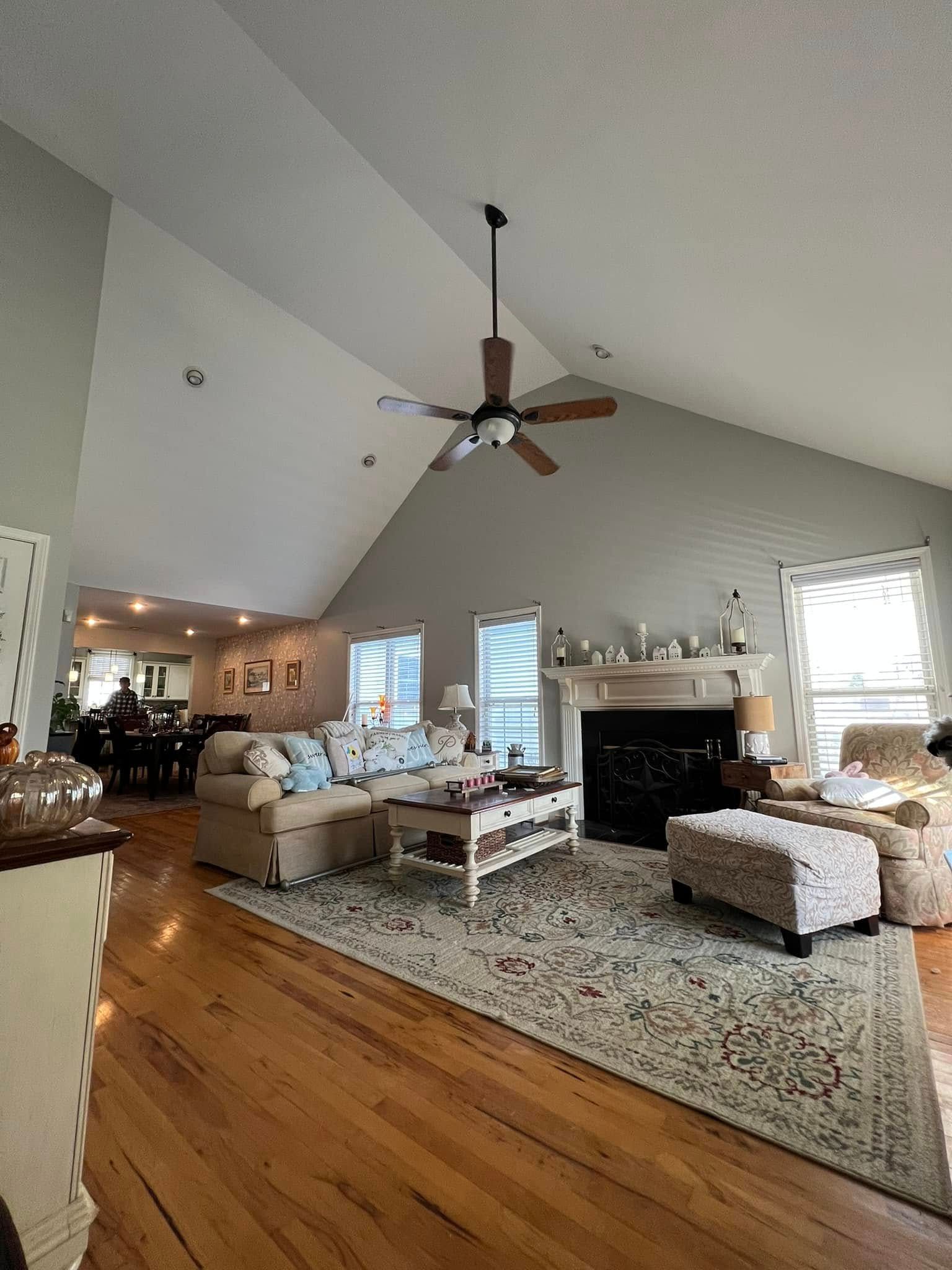Living room with vaulted ceiling, hardwood floors, fireplace, sofa, and coffee table.