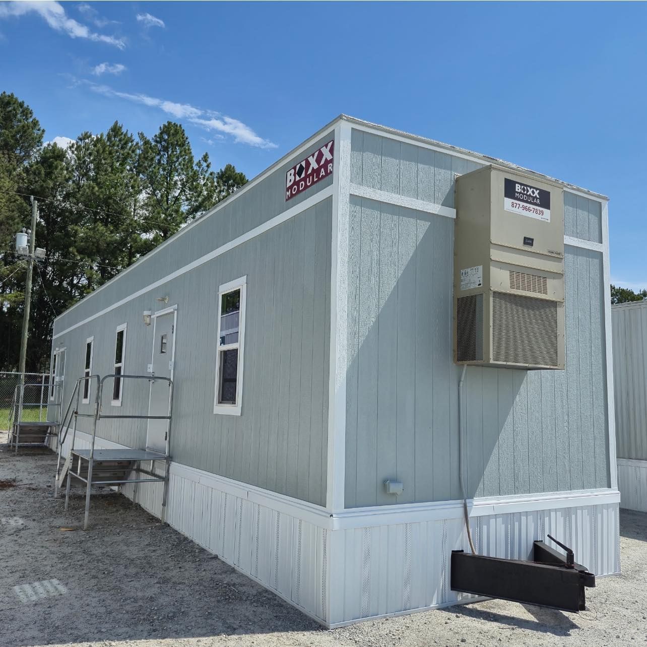 Light blue modular office building with an air conditioning unit outside.