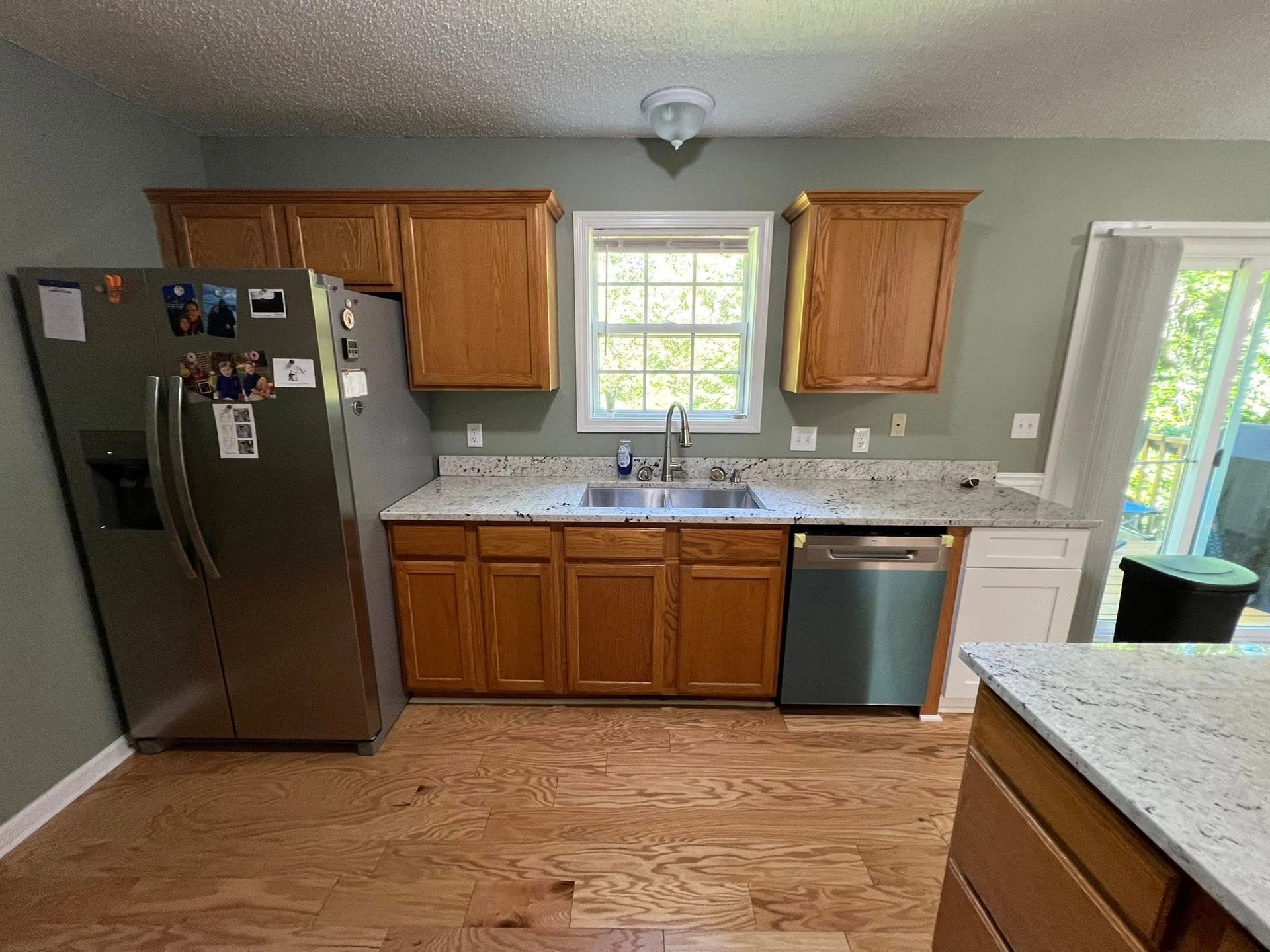 Kitchen with wood cabinets, granite countertops, stainless steel appliances, and hardwood floors.