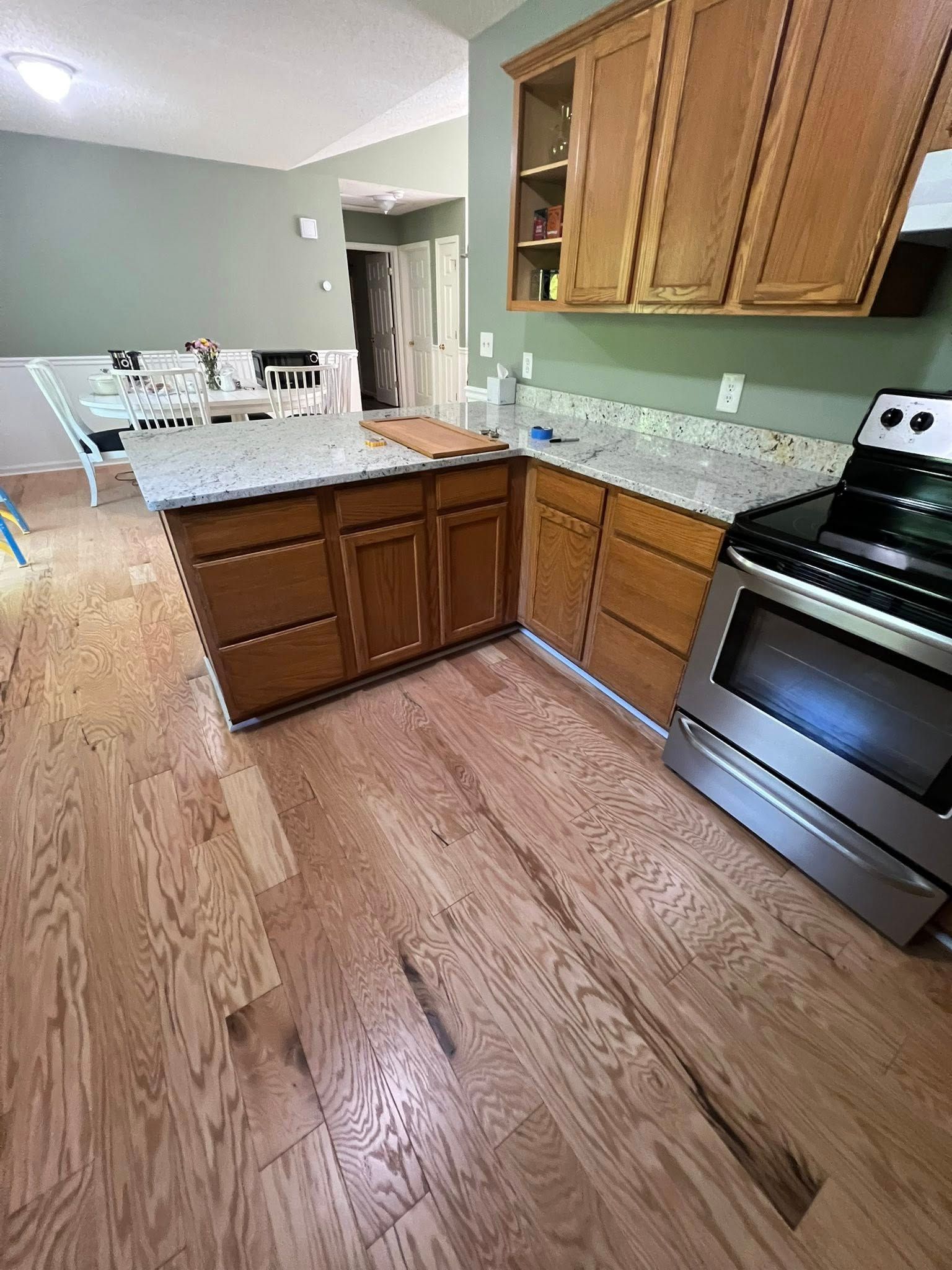 Kitchen with wood cabinets, countertops, and stainless steel oven. Hardwood floors.