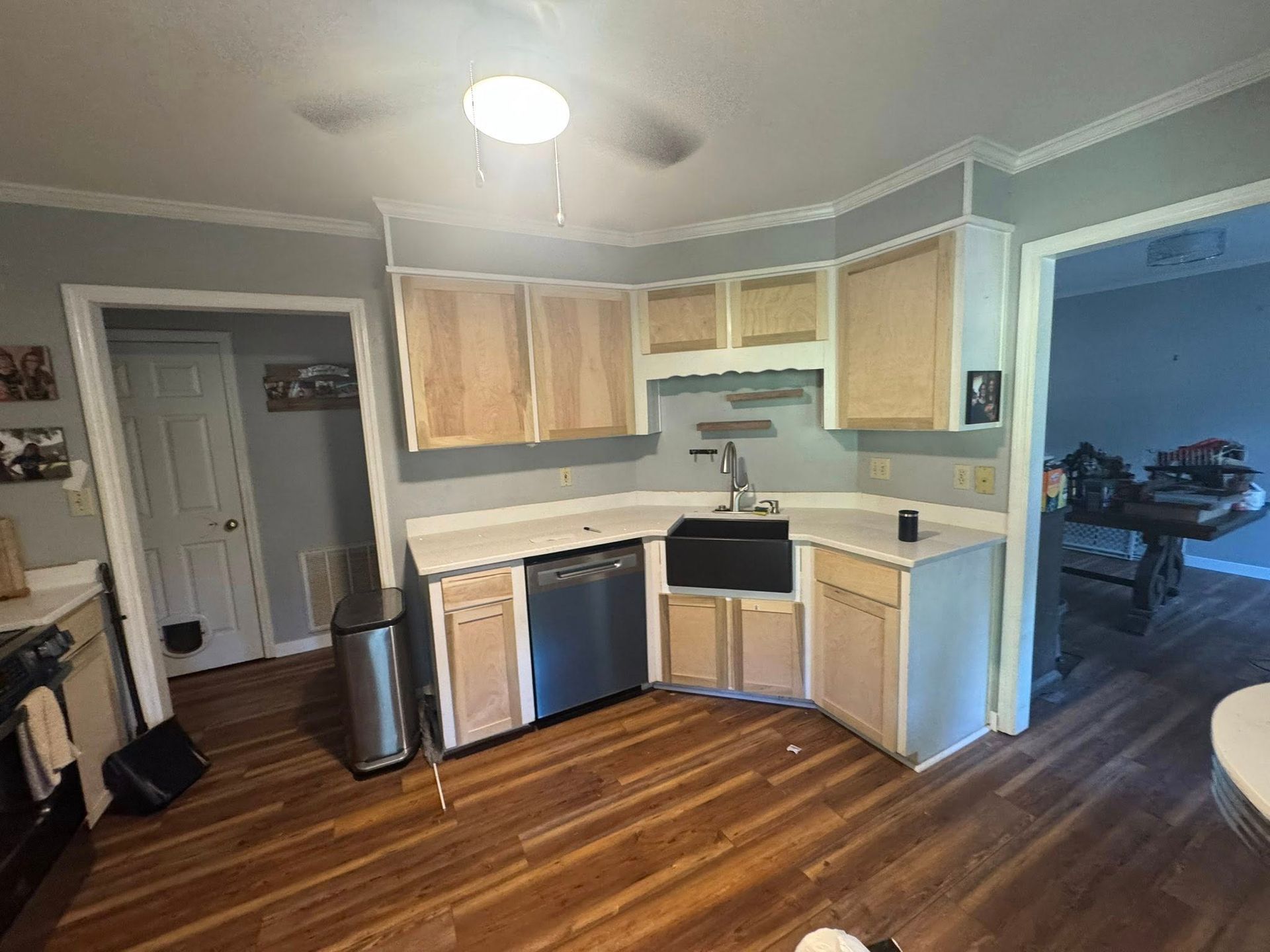 Kitchen with light wood cabinets, stainless steel appliances, white countertops, and hardwood floors.